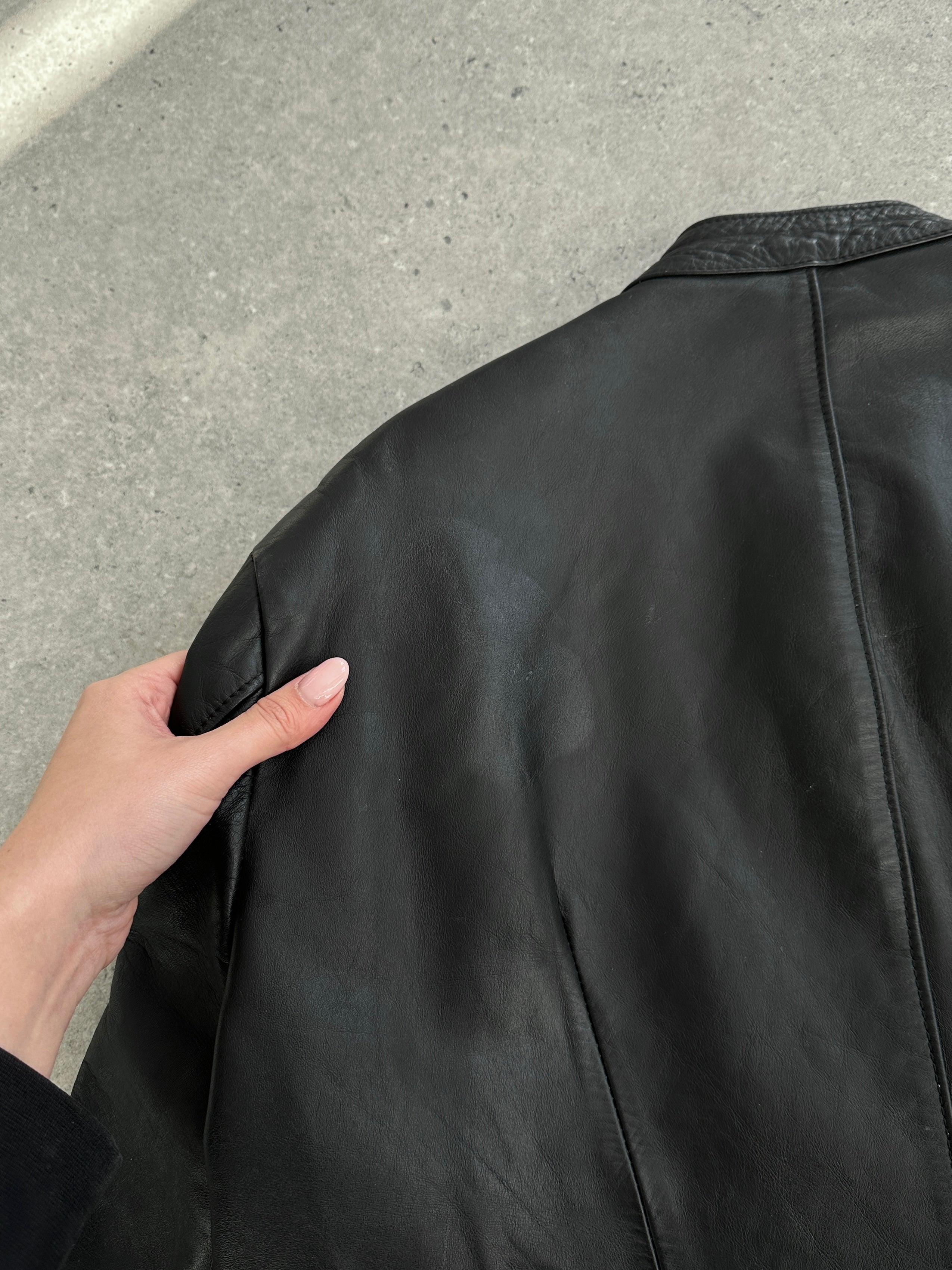 Vintage Leather Moto Jacket in size L, featuring classic design, zipper details, and distressed finish, styled on a hanger.