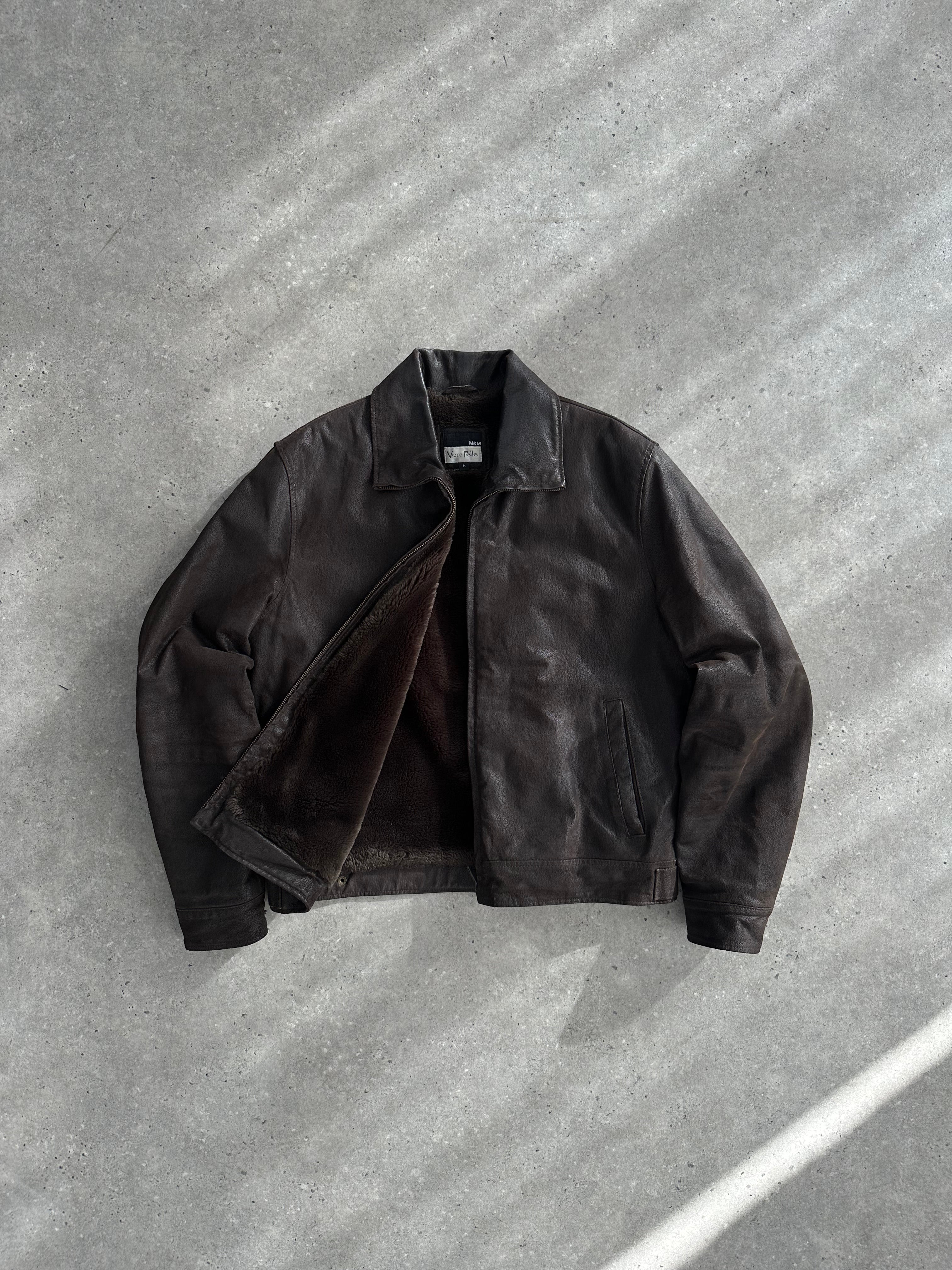 Vintage fur-lined leather jacket in size M/L, showcasing a classic design with warm fur interior and rugged leather exterior.