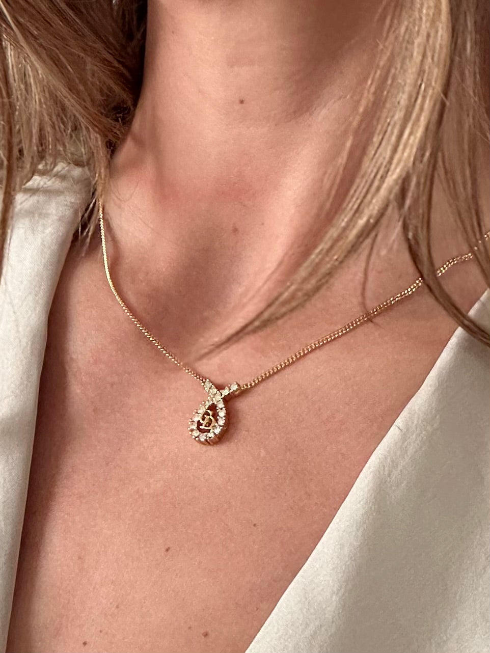 Christian Dior 16-inch gold plated rhinestone drop logo pendant necklace, featuring a sparkling designer jewelry piece.