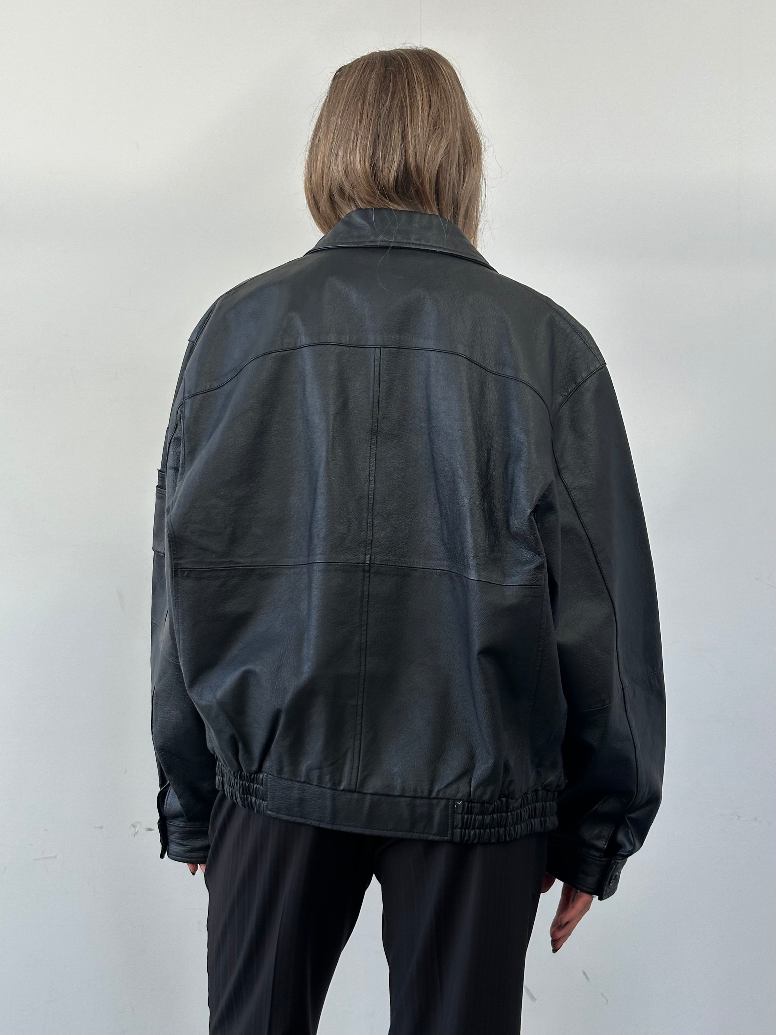 Vintage Leather Bomber Jacket in XL size, featuring classic design and rich brown leather, displayed on a hanger.