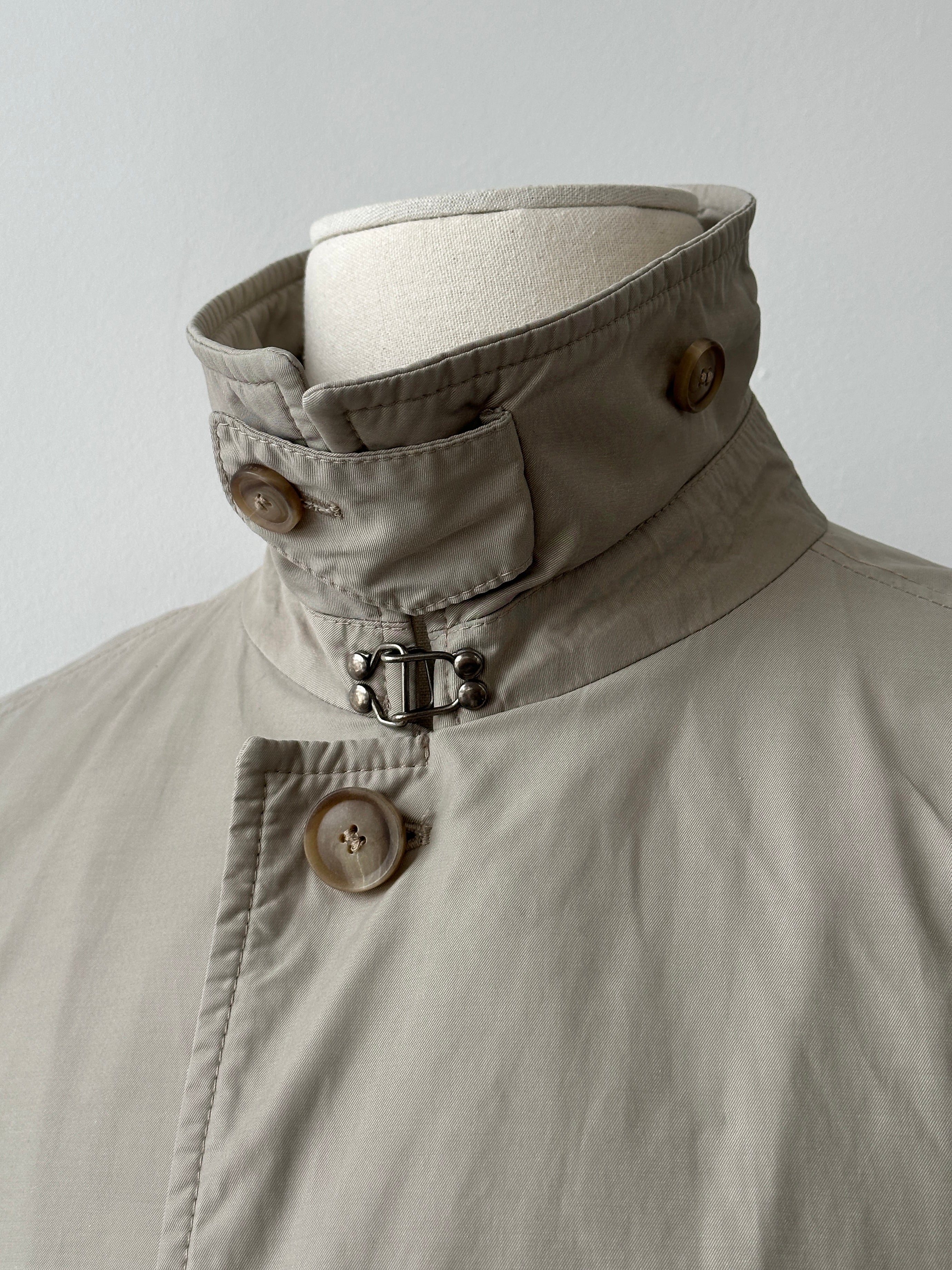 Hugo Boss 2000s high neck belted trench coat in beige, displayed on a hanger, showcasing its classic design and modern style.
