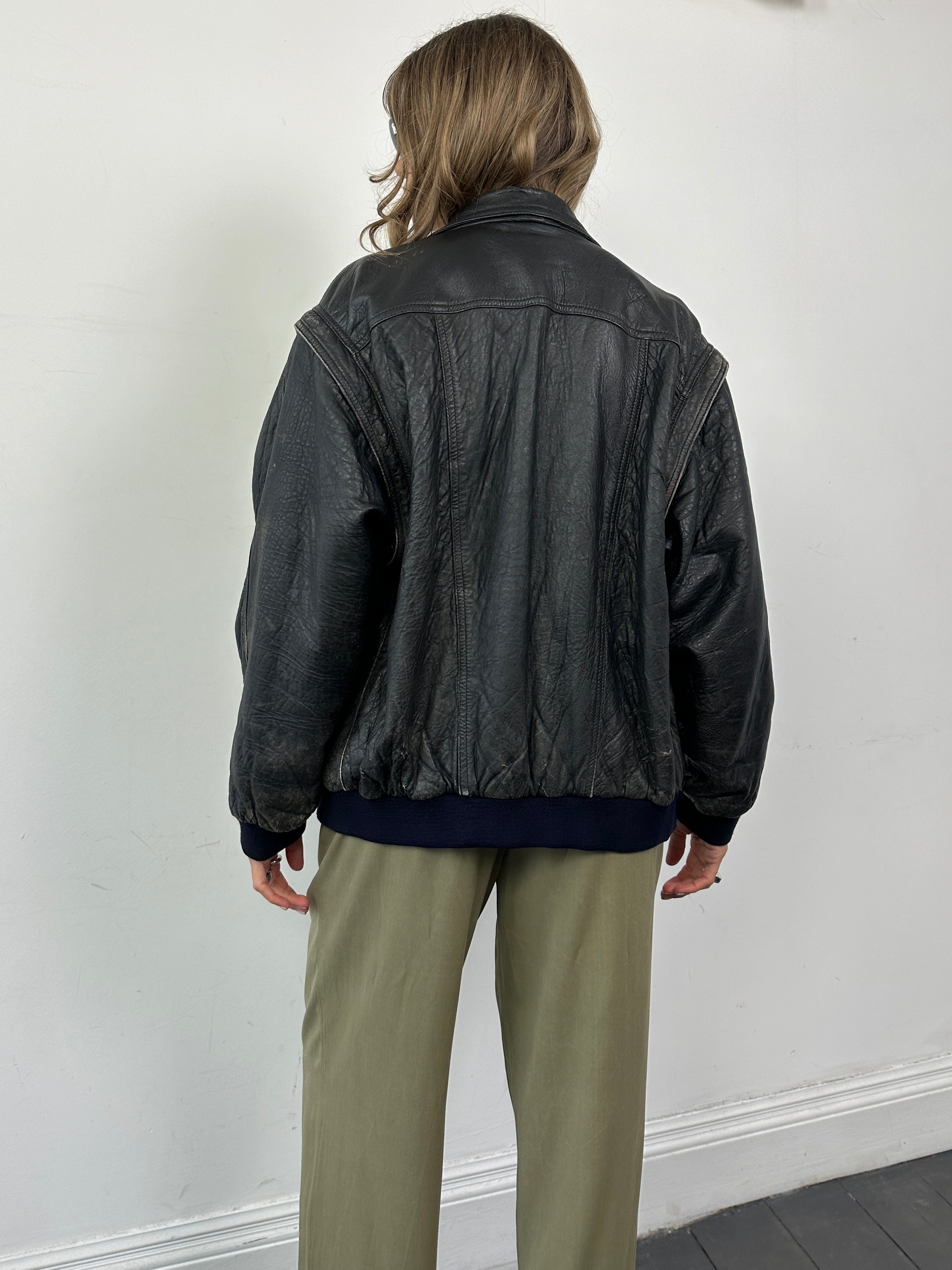 Vintage distressed leather bomber gilet jacket, men's size M/L, with rugged, vintage-style design and distressed leather texture.