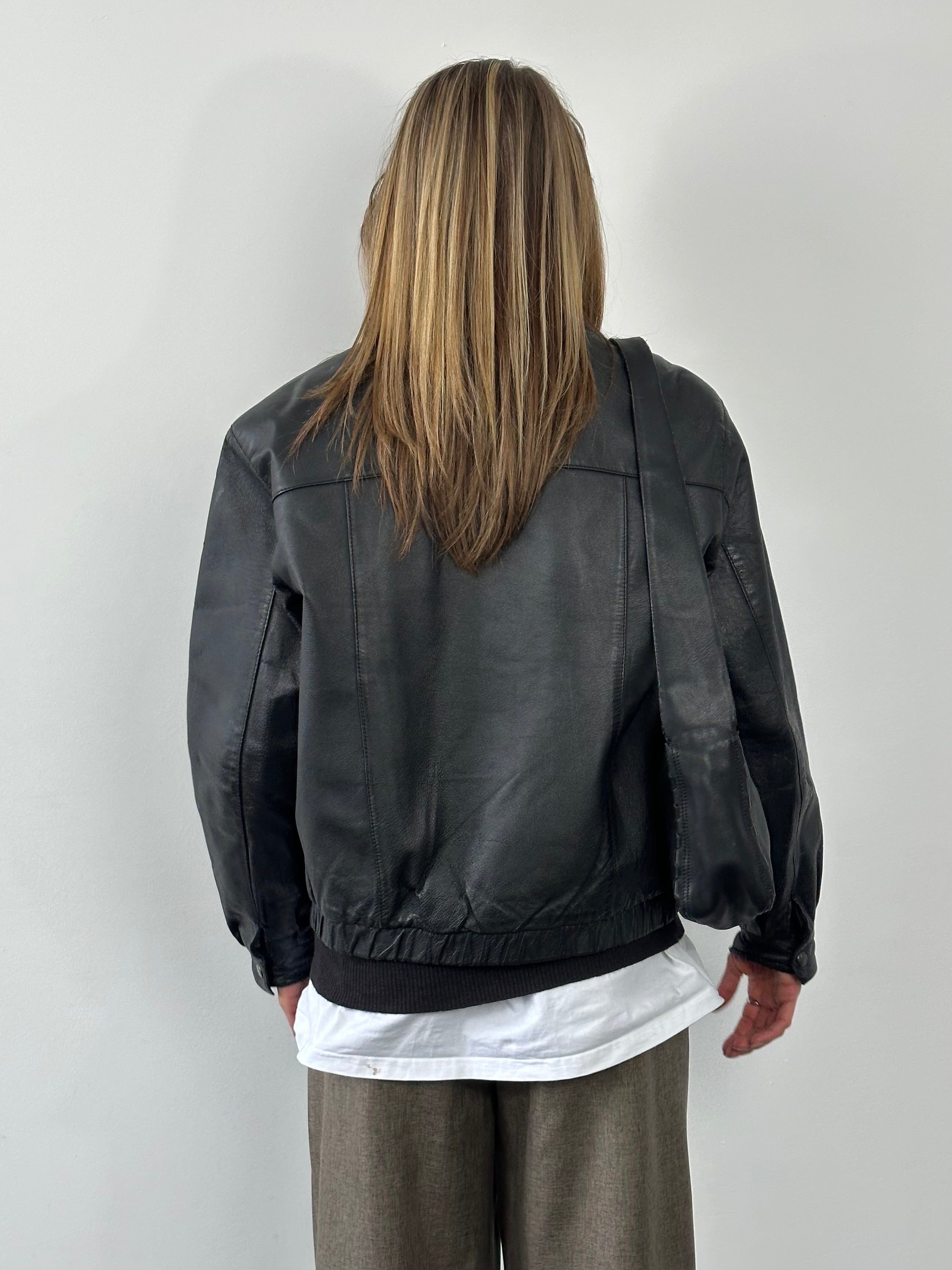 Vintage 1990s leather bomber jacket in medium size, featuring classic design and authentic leather construction.