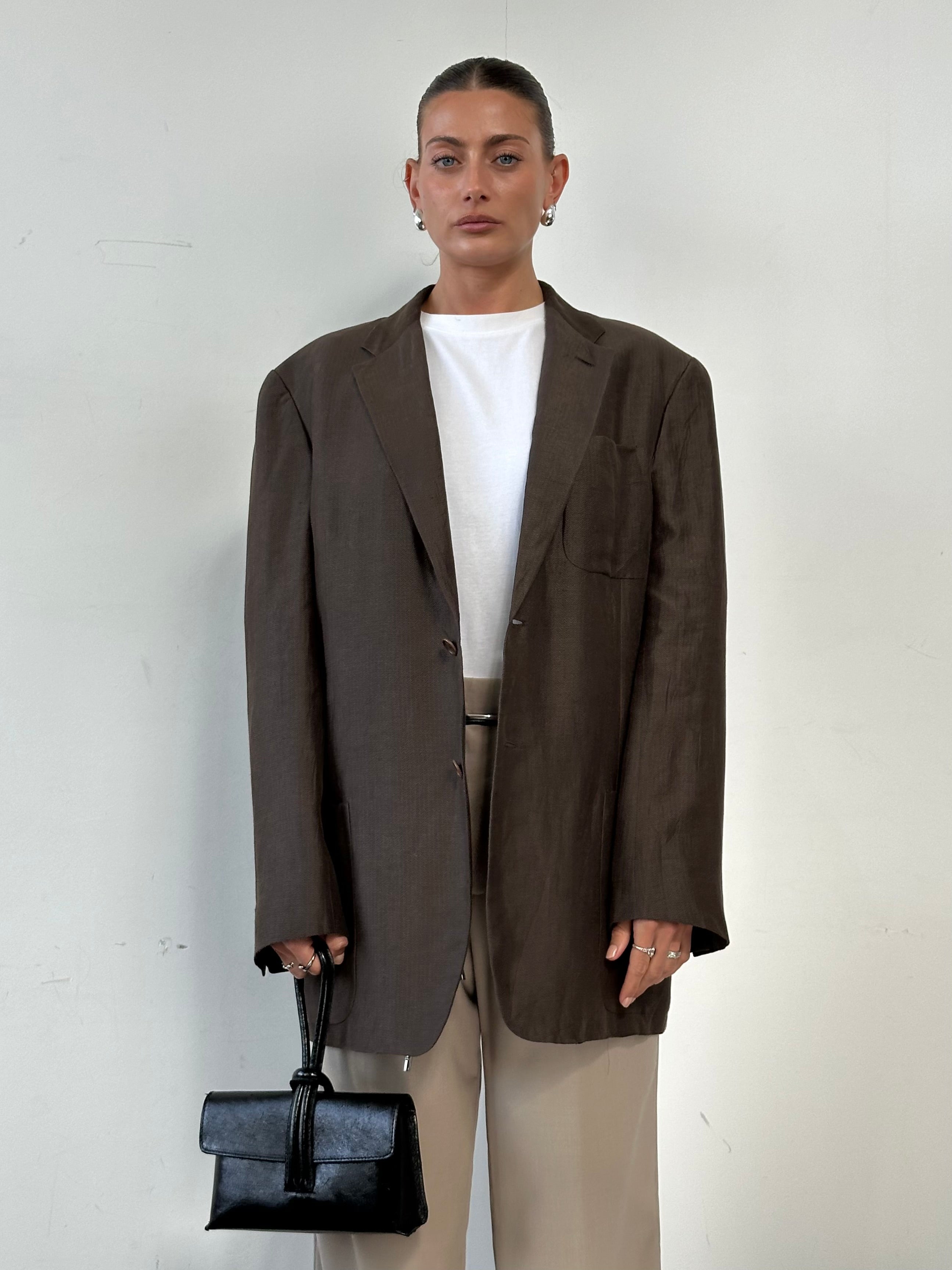 Giorgio Armani Black Label 1990s silk linen blazer in black, size 42R/XL, displayed on a hanger showcasing its tailored fit.