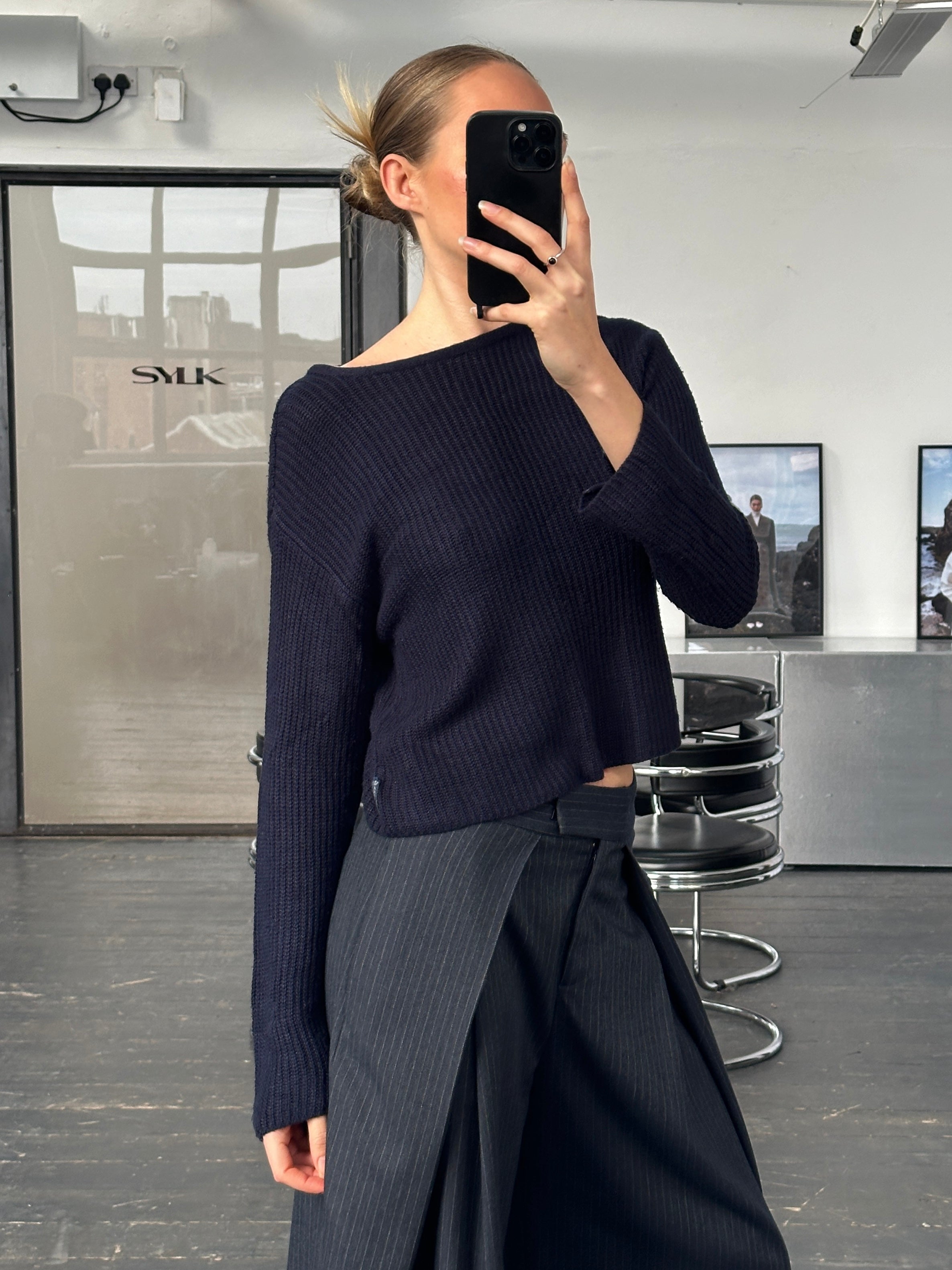 Armani Jeans 1990s cropped knitted jumper in black, featuring a fitted style and ribbed cuffs, displayed on a hanger.
