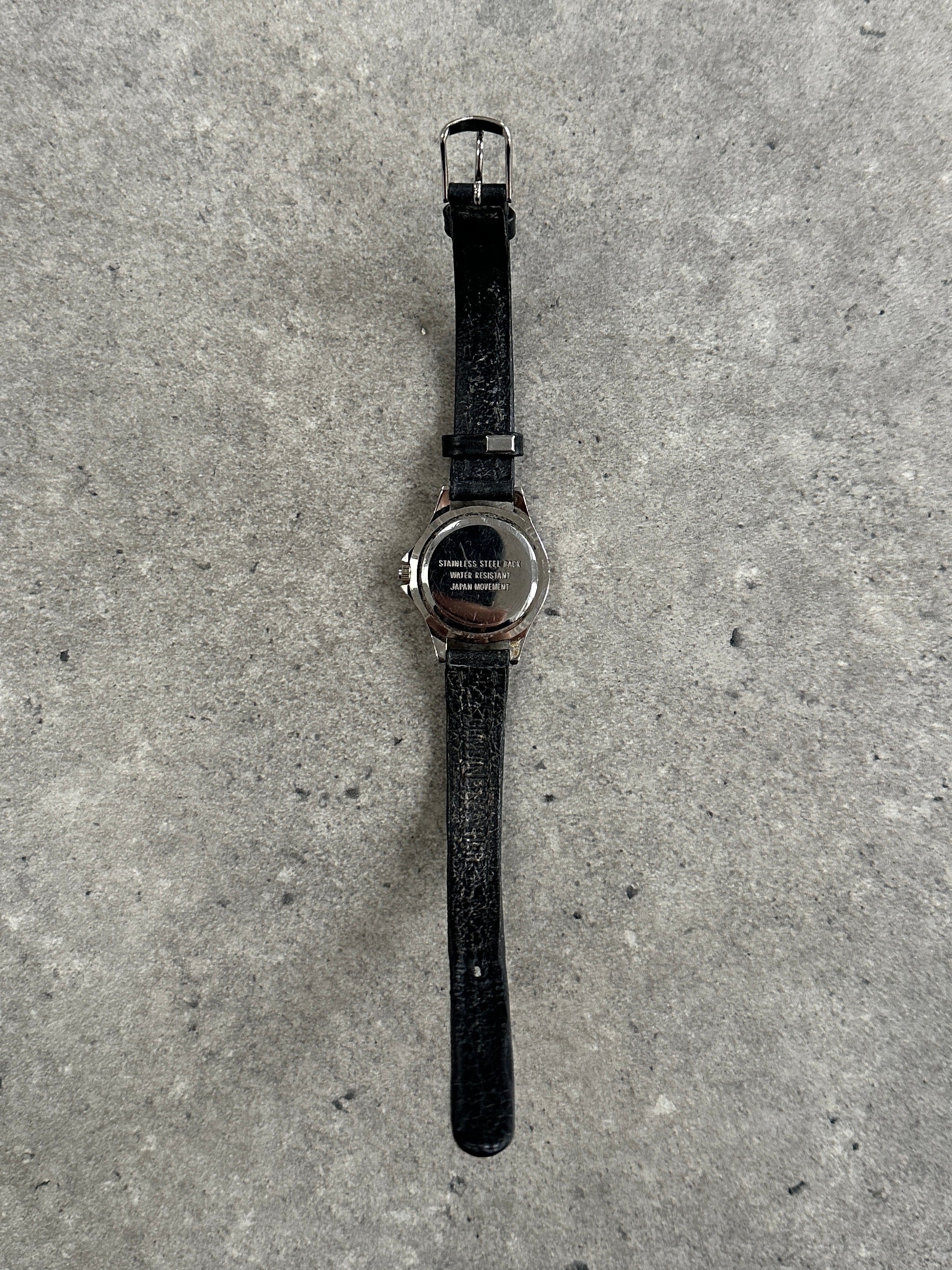 Vintage 1990s silver-tone quartz watch with round face and Japan movement, classic vintage wristwatch design.