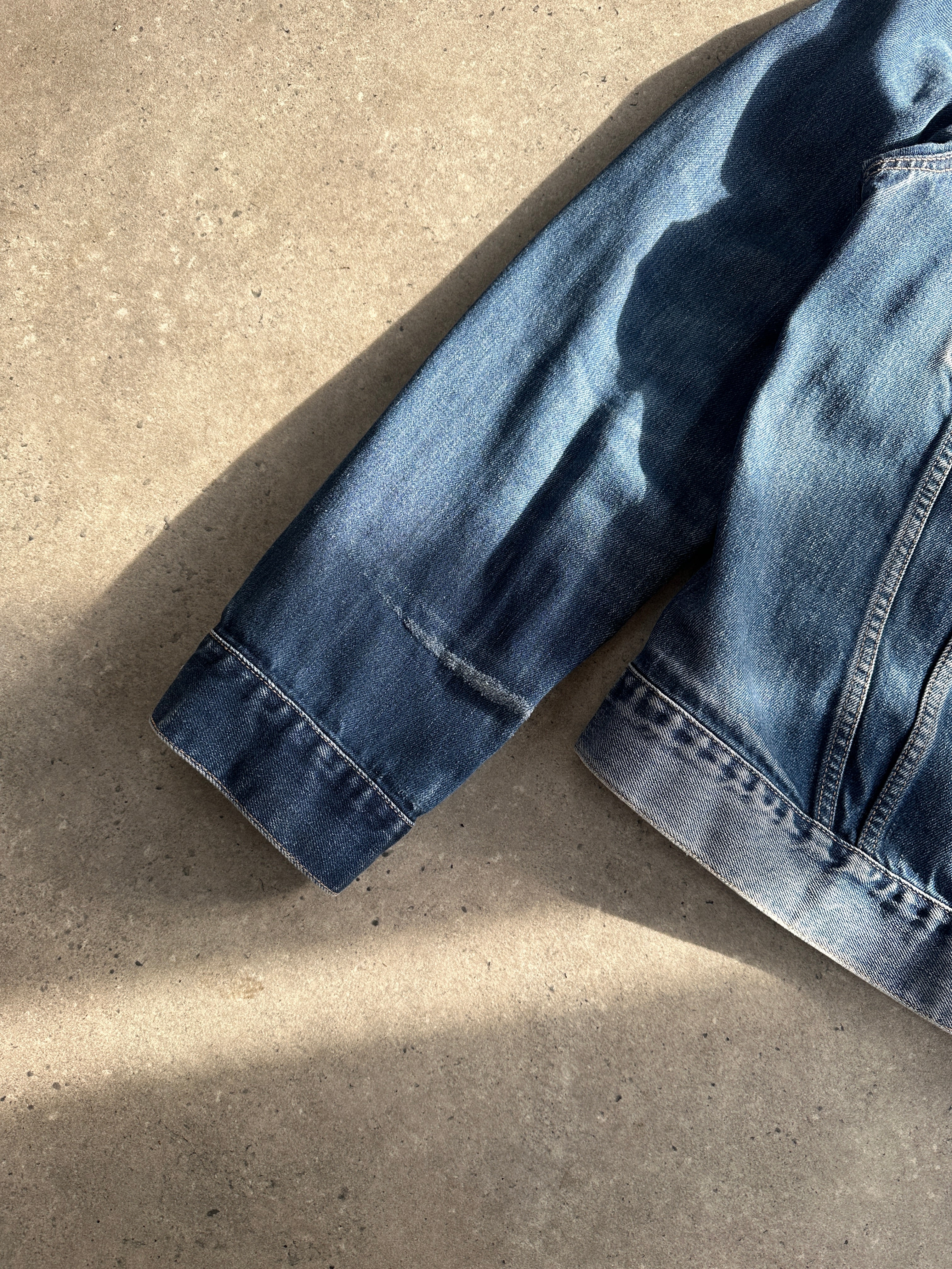 Levi’s faded denim jacket in size large, featuring classic button closure and distressed denim fabric.