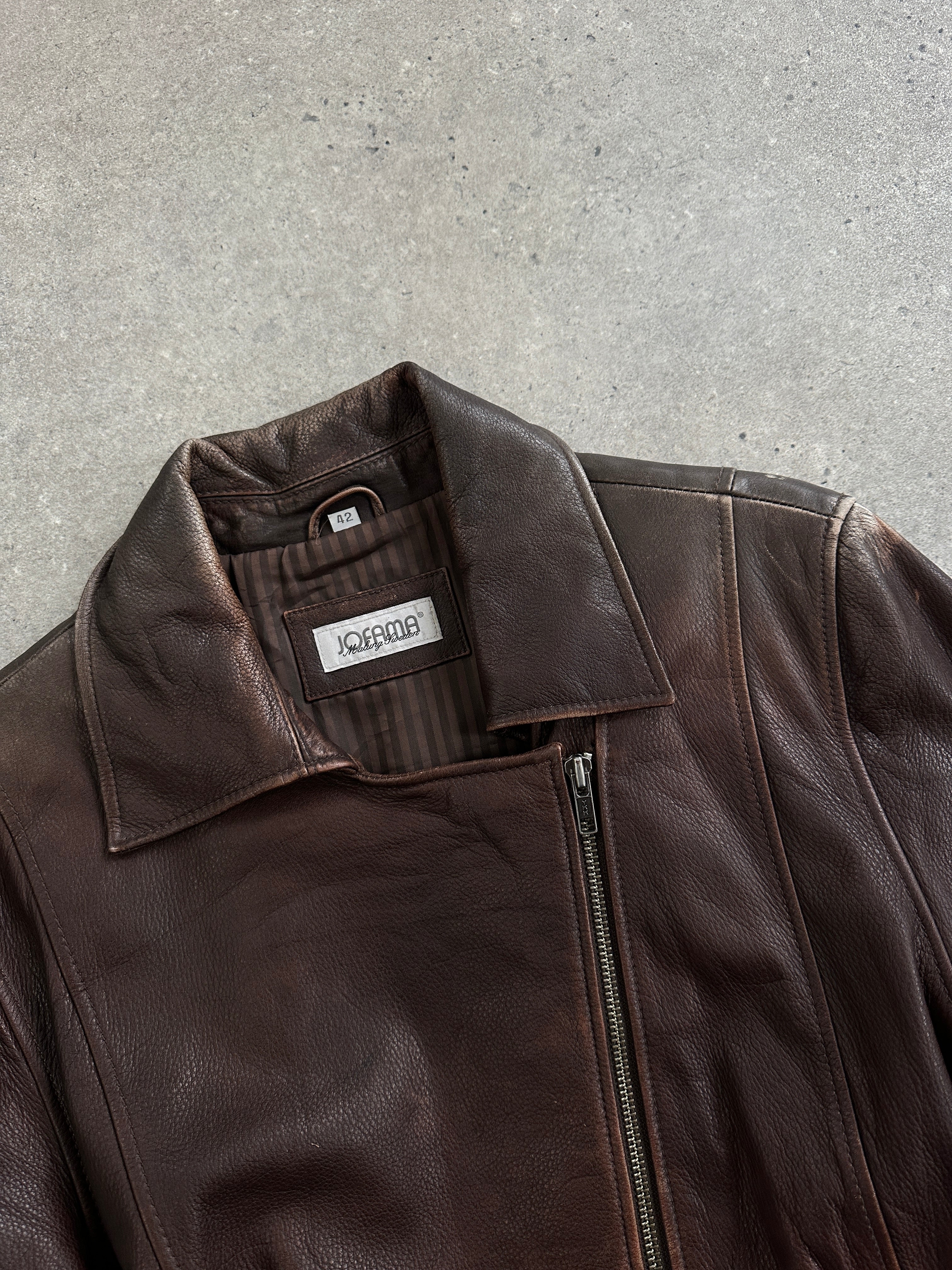 Vintage 1990s aged leather jacket with double zip and belt, featuring classic style and distressed leather details.