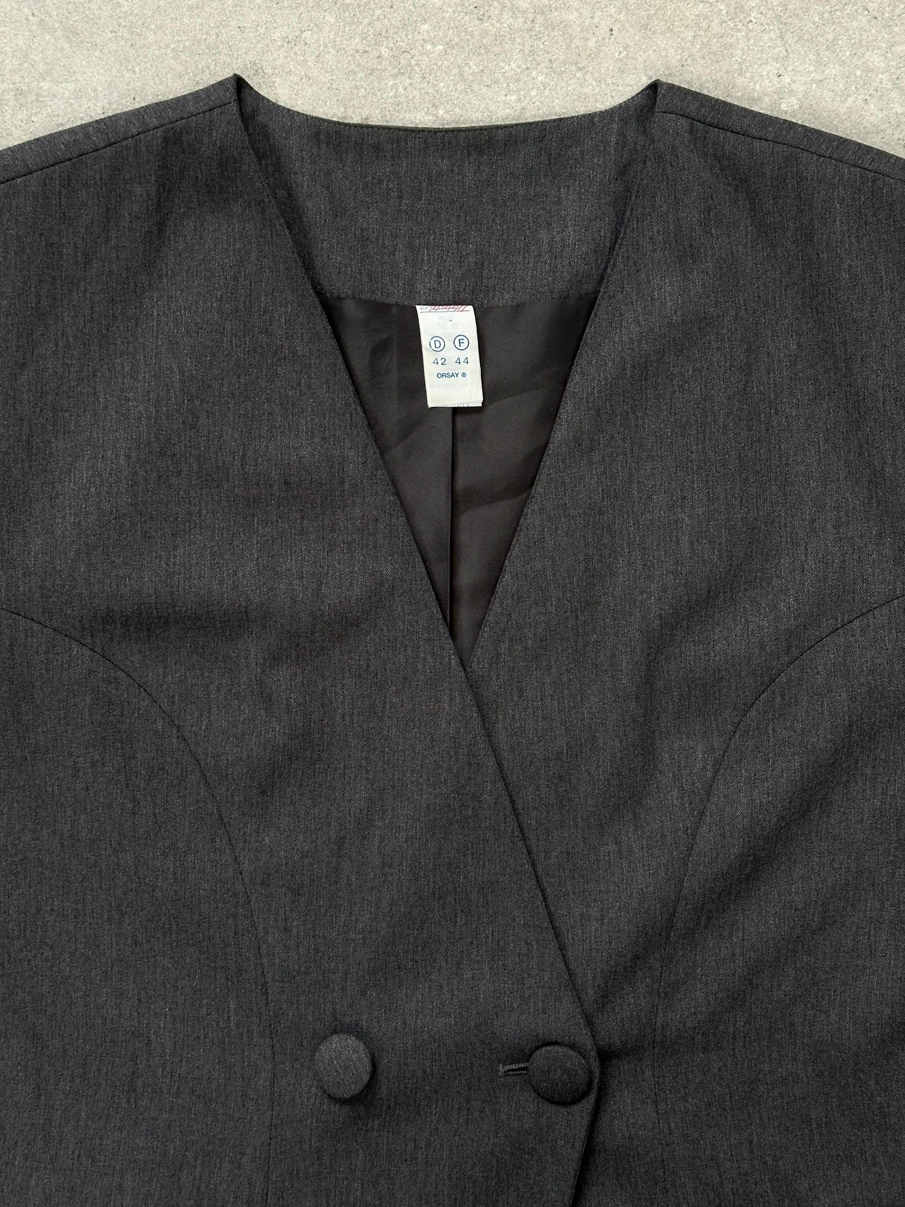 Vintage 1990s minimal collarless blazer in M/L size, showing a tailored design with clean lines and classic mid-century style.