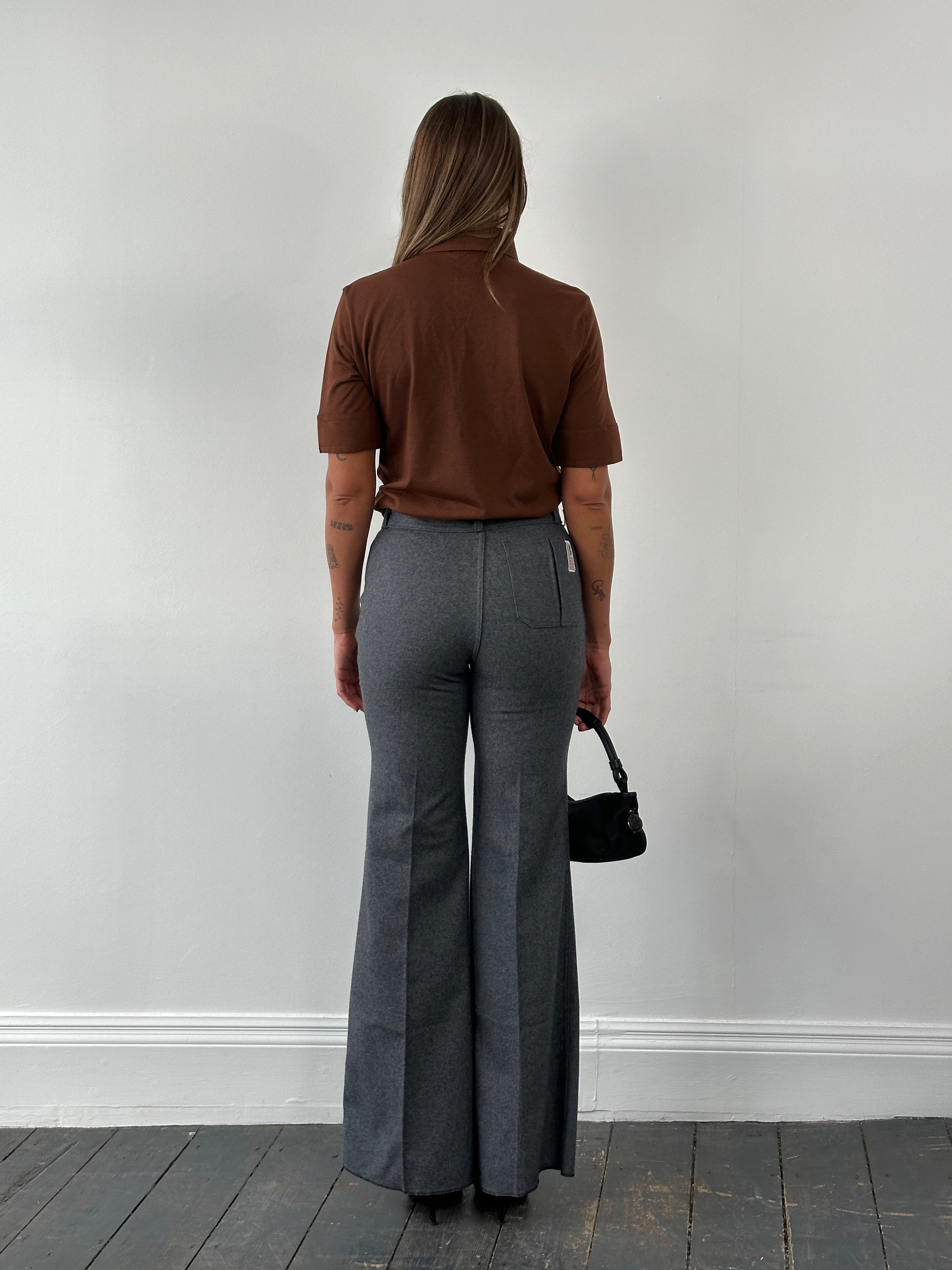Vintage Italian 1970s wool flared tailored trousers, size W28, featuring retro high-waisted design and classic tailored fit.