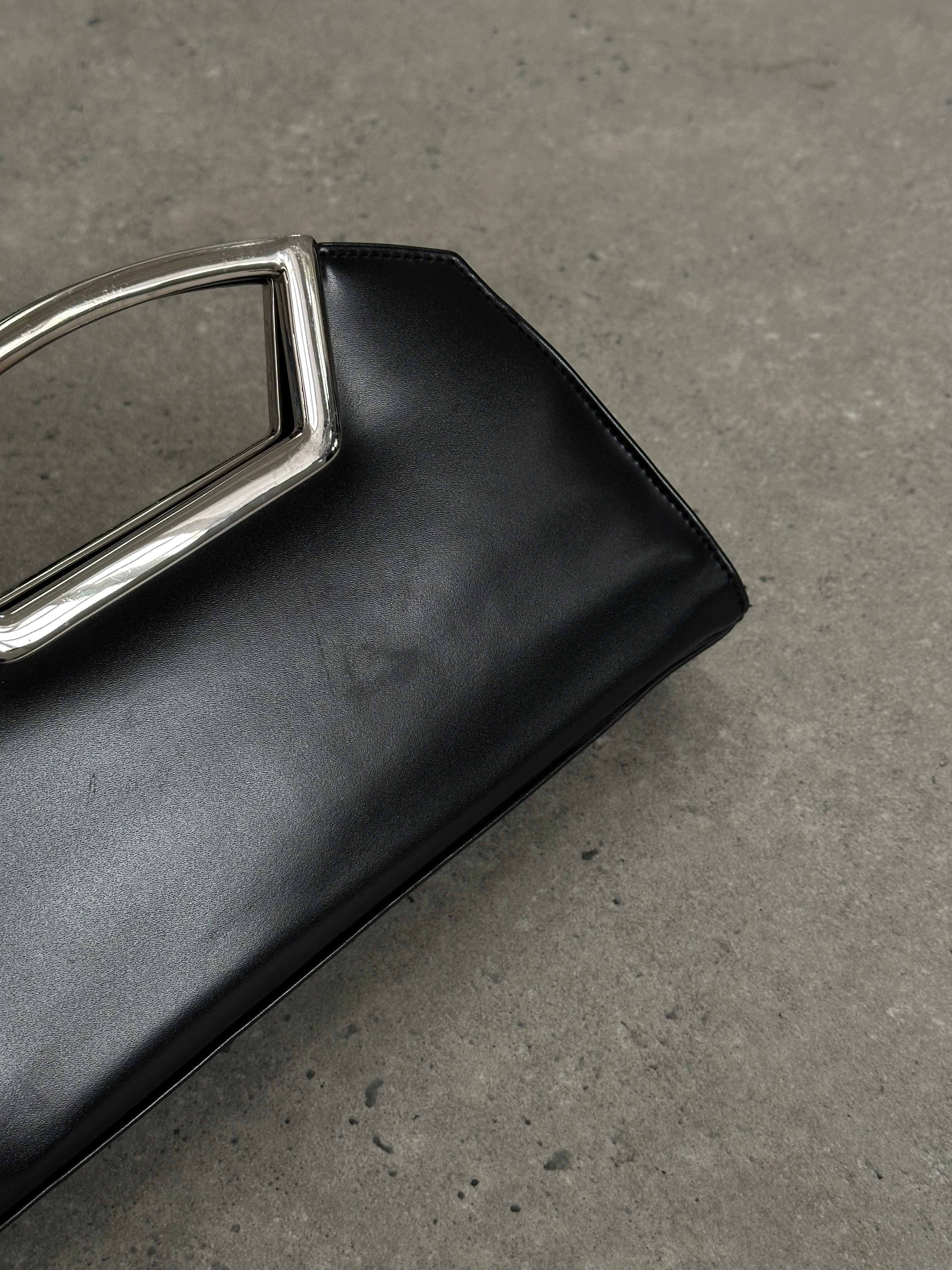 Vintage leather chrome crossbody clutch bag with a sleek design, featuring a compact, stylish accessory for everyday use.