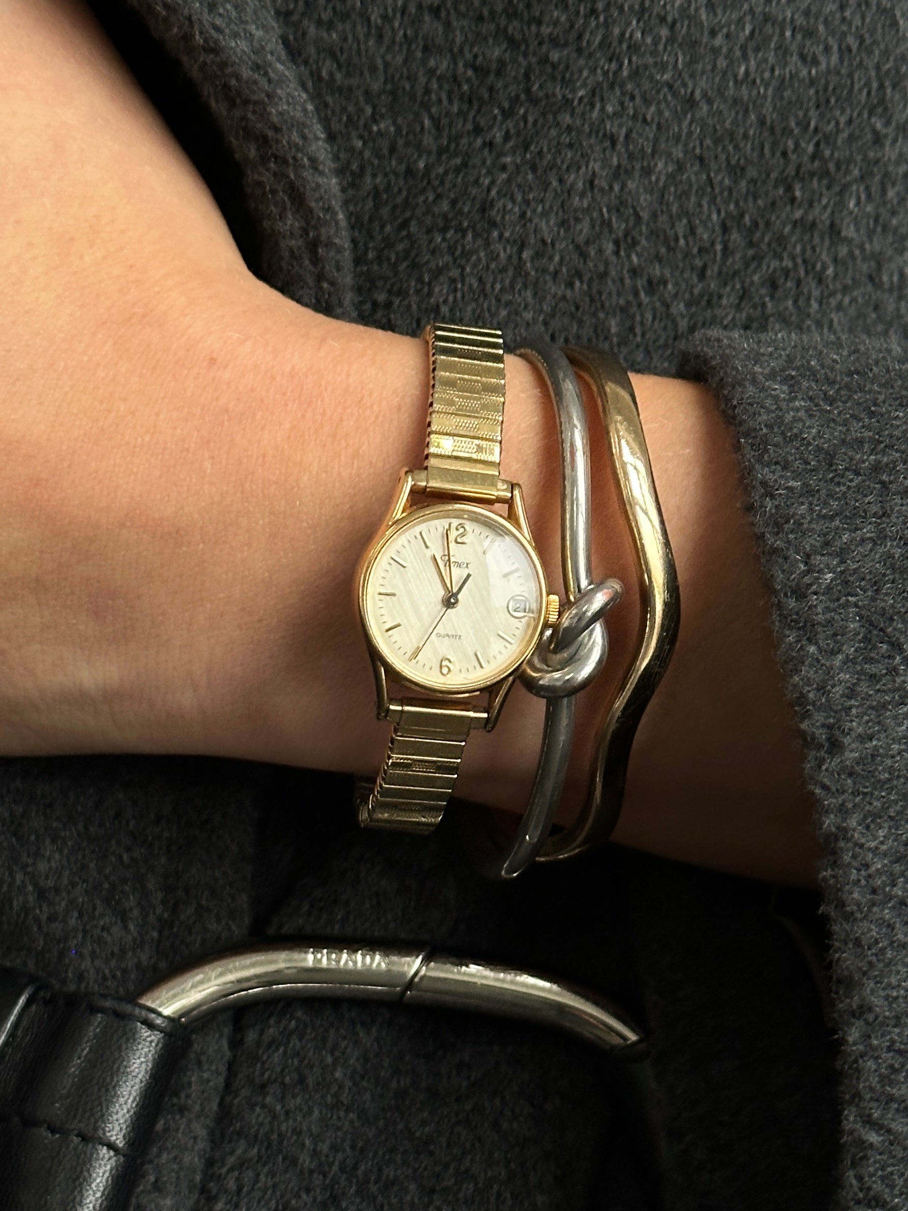 Timex 1990s round gold-tone quartz watch with a classic dial and sleek design, featuring a metal bracelet strap.