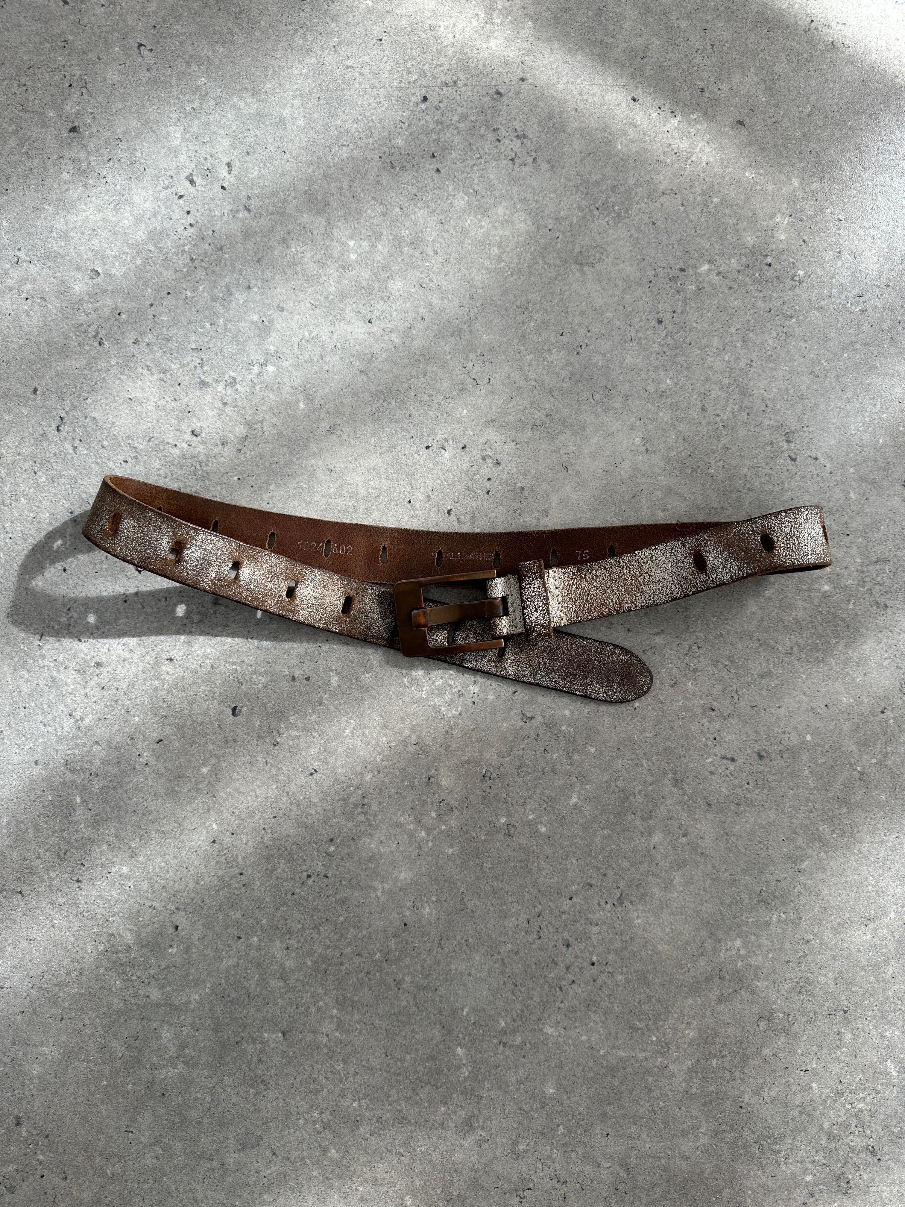 Vintage distressed leather belt from the 1980s with natural wear and tear, featuring a classic buckle and aged leather finish.