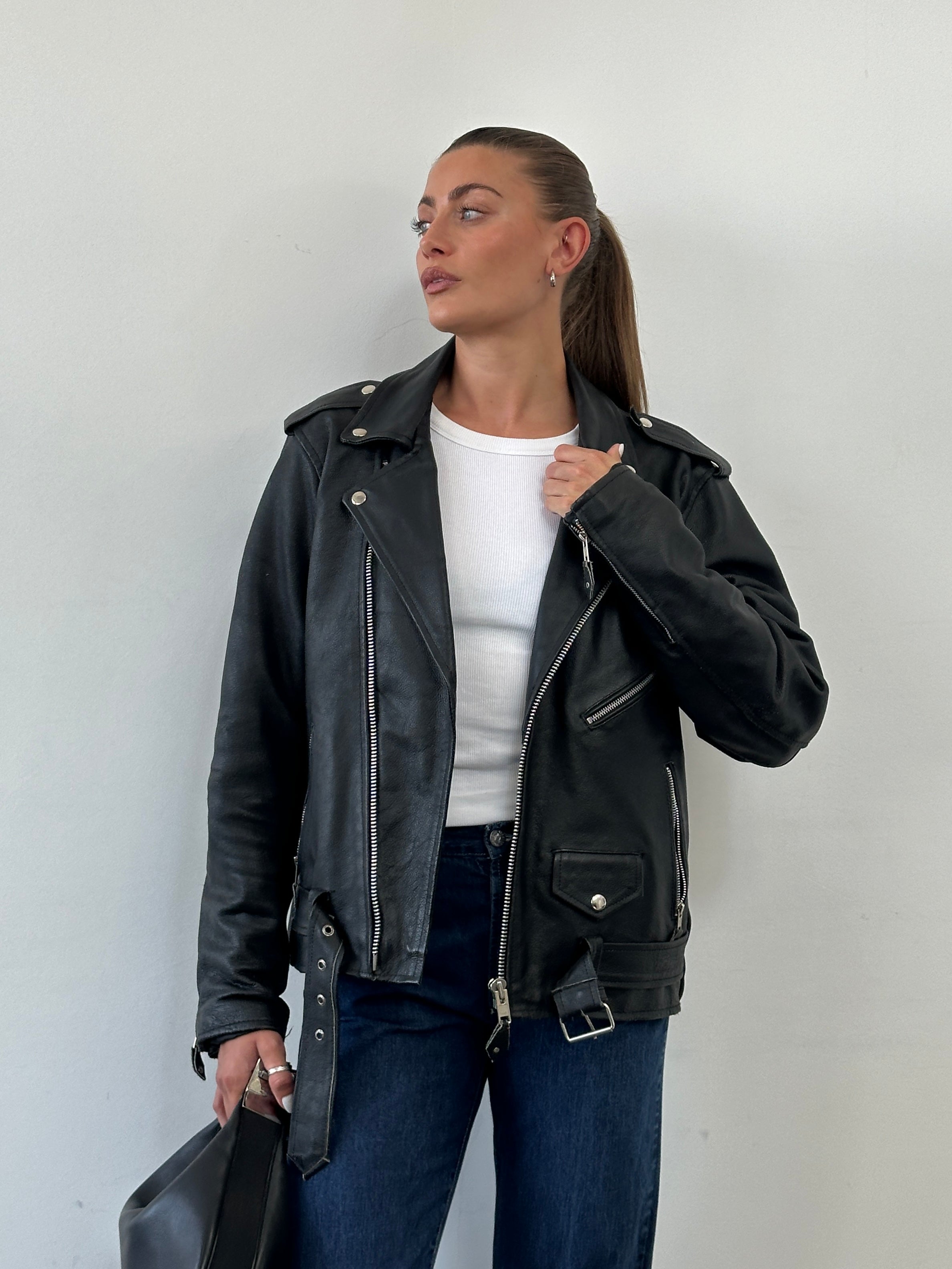 Vintage leather biker jacket in size M/L, showcasing classic design with rugged leather and detailed stitching.