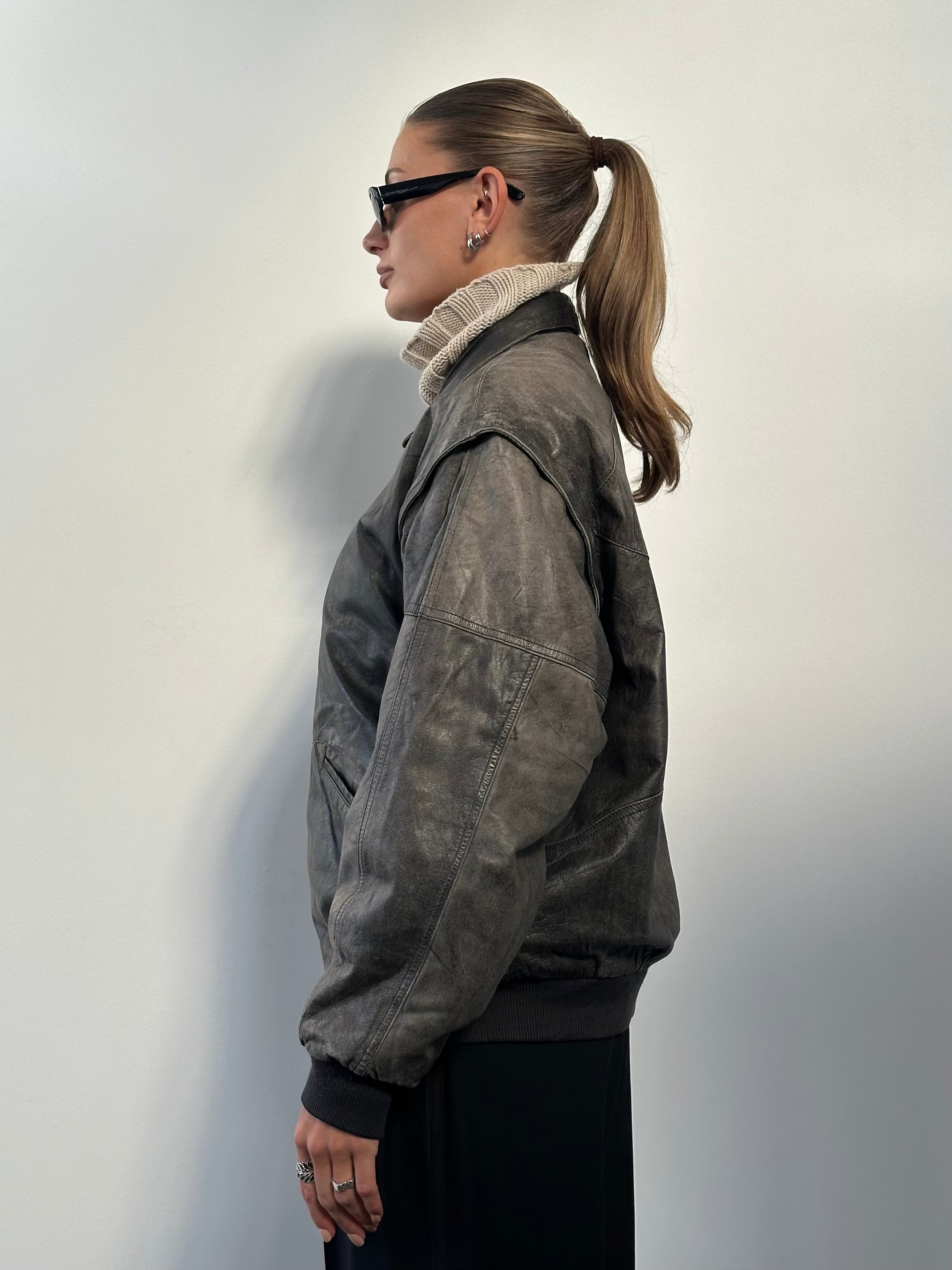 Vintage distressed leather bomber jacket in size L/XL, featuring a rugged, worn-in look and classic bomber style.