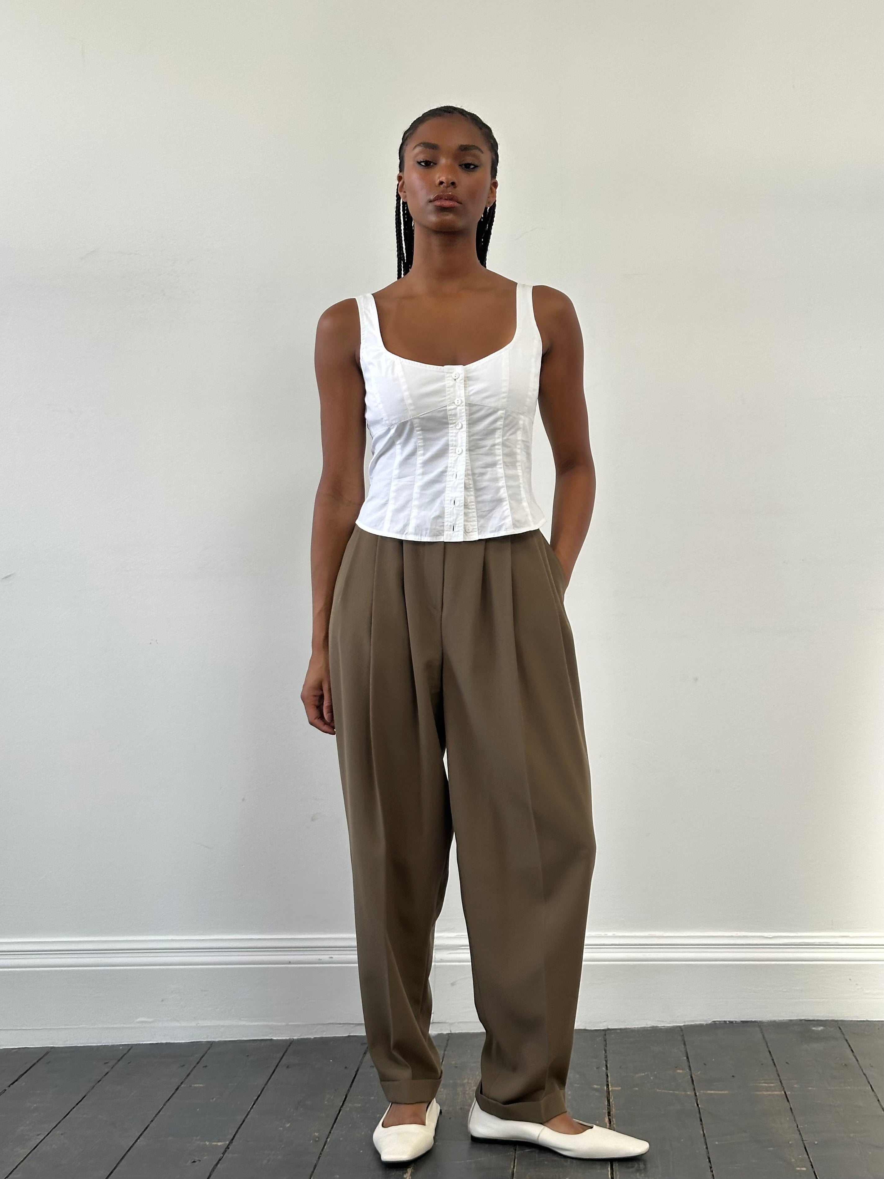 Vintage 1990s high-waisted pleated tailored trousers in a classic fit, displayed on a hanger with a neutral background.