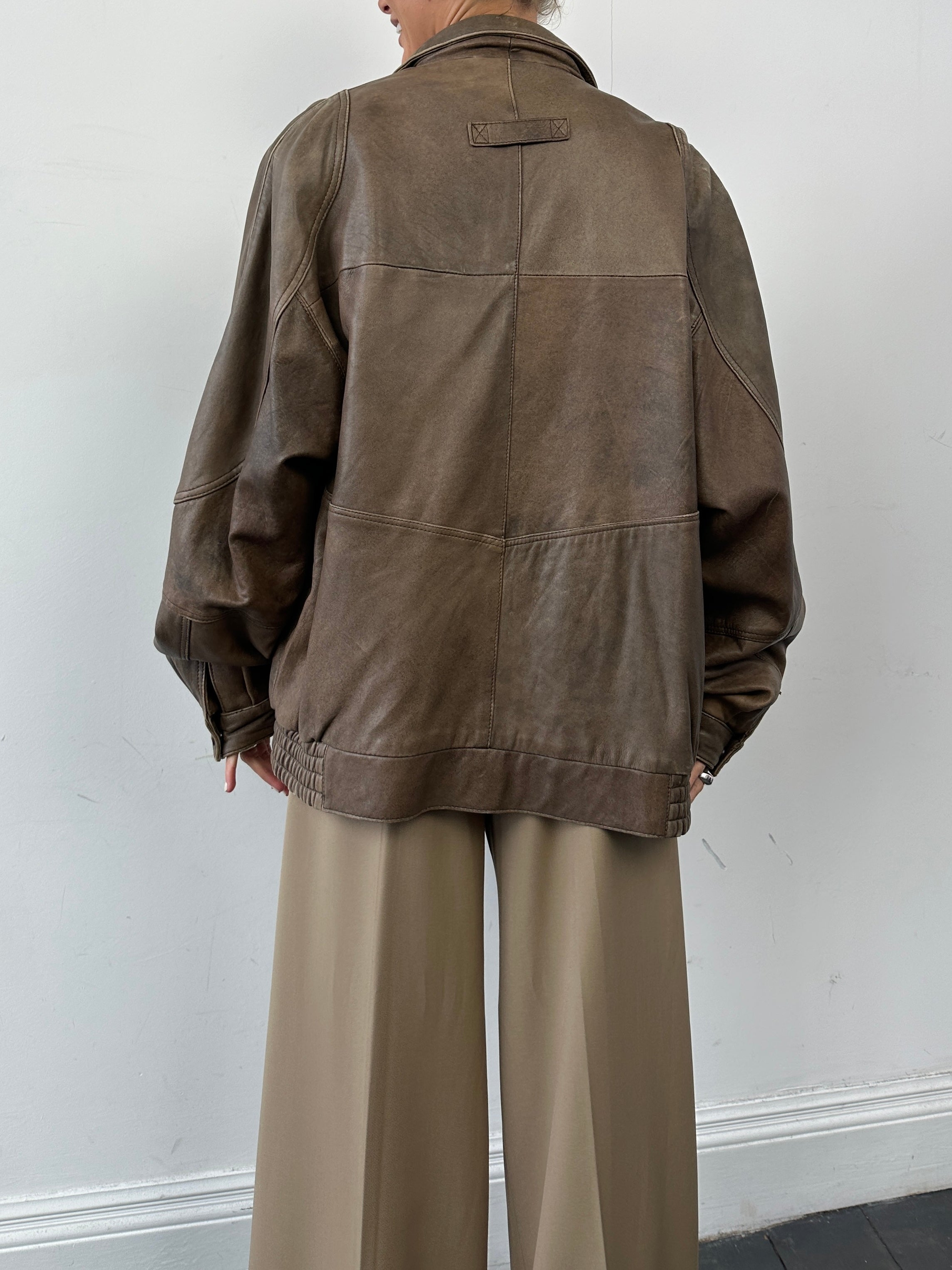 Vintage leather bomber jacket in XL/XXL, featuring classic design, brown leather, and ribbed cuffs and collar.