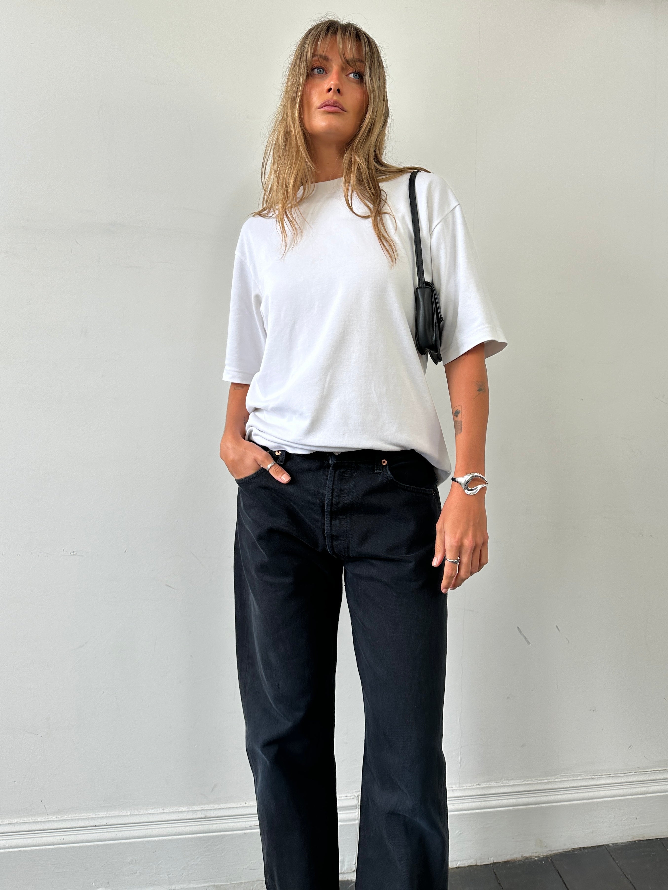 Levi’s 501 high-waisted straight-leg denim jeans in W32, showcasing classic blue denim with a button fly and five-pocket design.