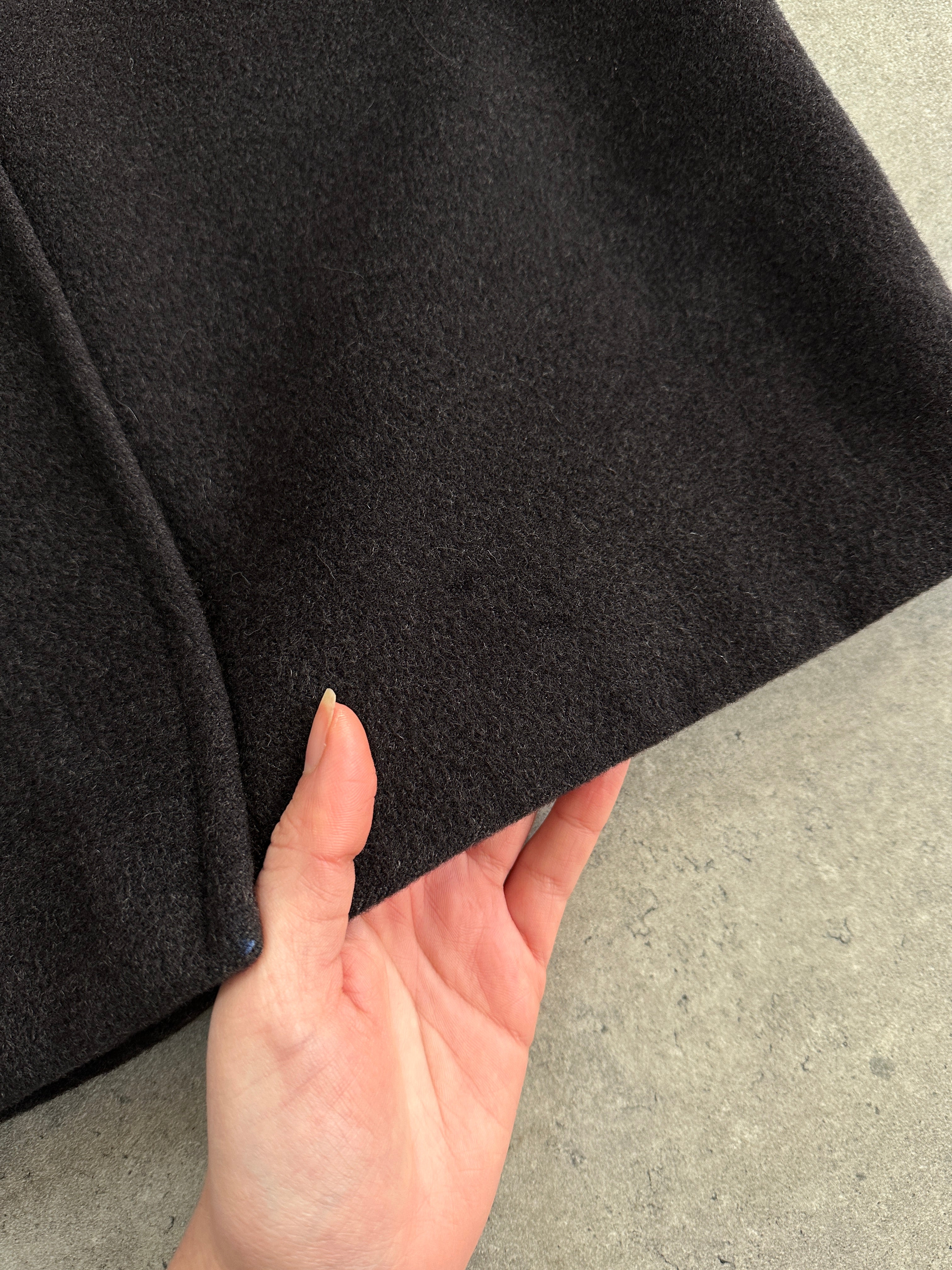 Max Mara pure wool double-breasted coat in size M displayed on a hanger, showcasing classic tailored design and neutral color.