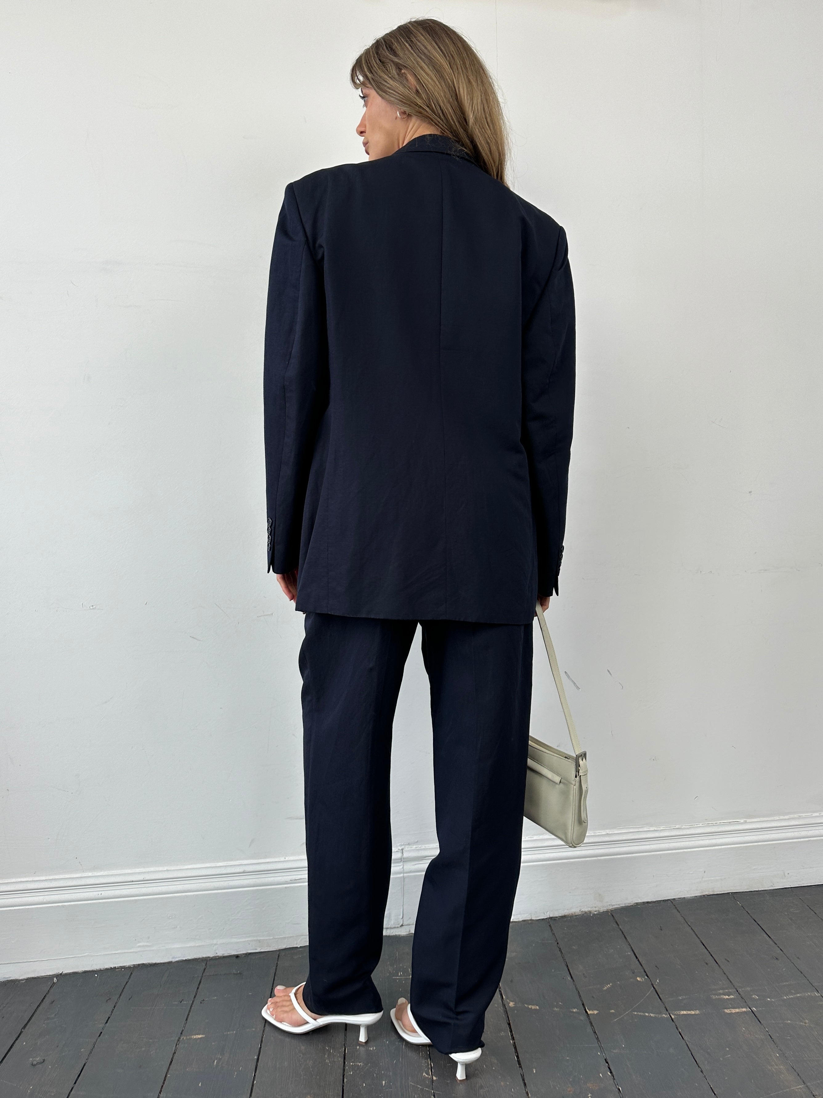 Yves Saint Laurent Pour Homme linen silk single-breasted suit in size 42R/W34, displayed on a hanger with fabric details visible.