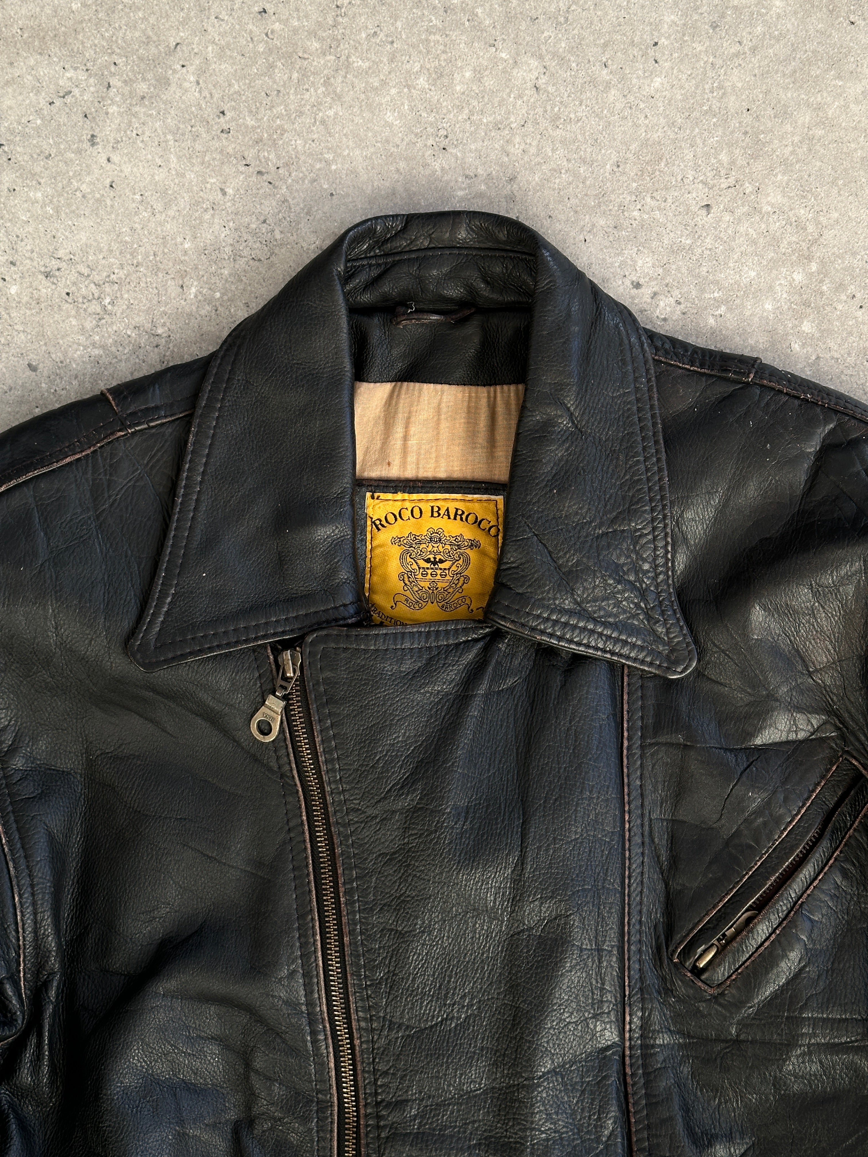 Vintage distressed leather jacket in XL size, featuring rugged texture and classic style, shown on a hanger.