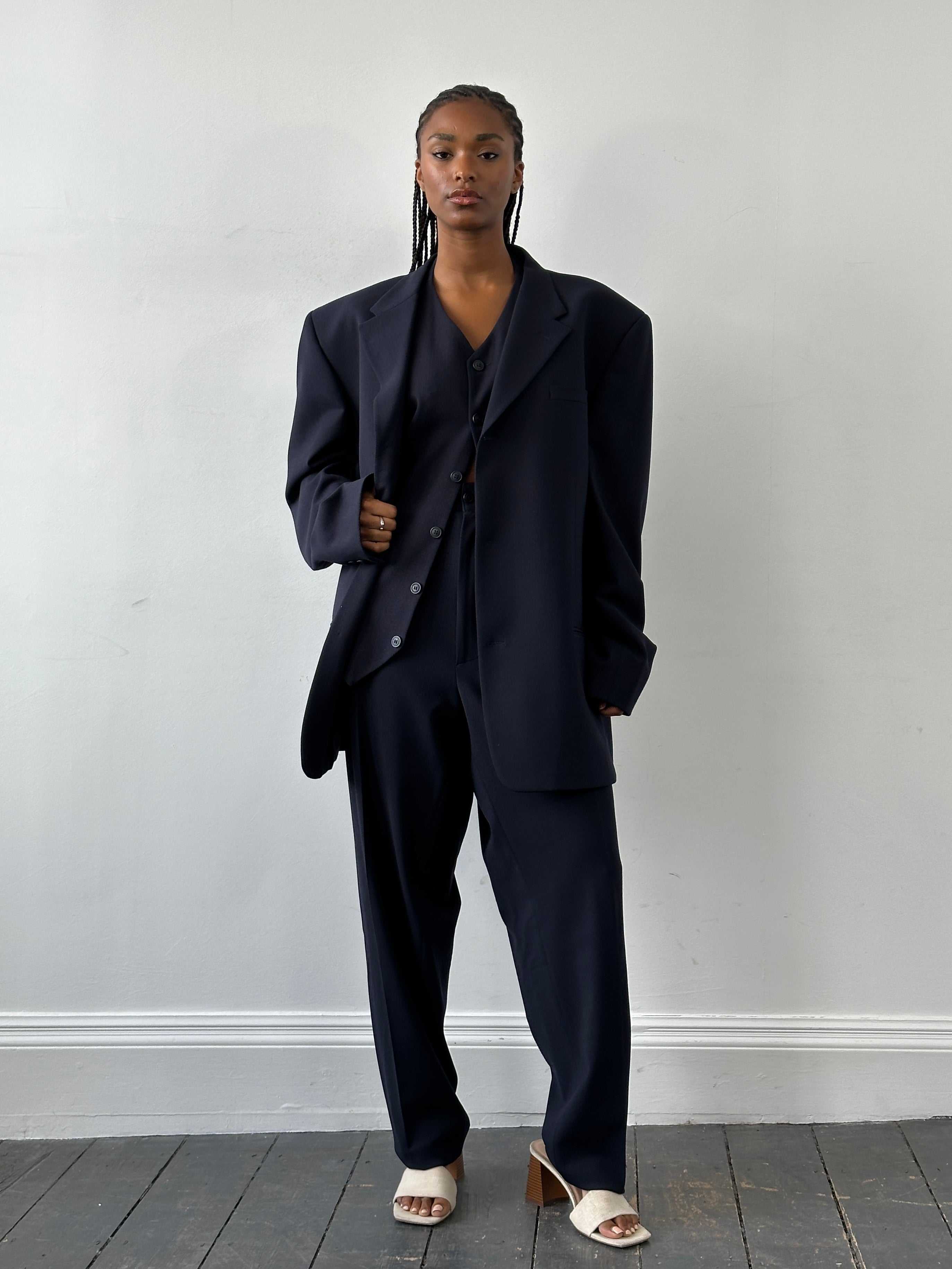 Versace Versus 1990s three-piece suit in size 48R/W32, featuring tailored jacket, vest, and trousers with bold pattern.