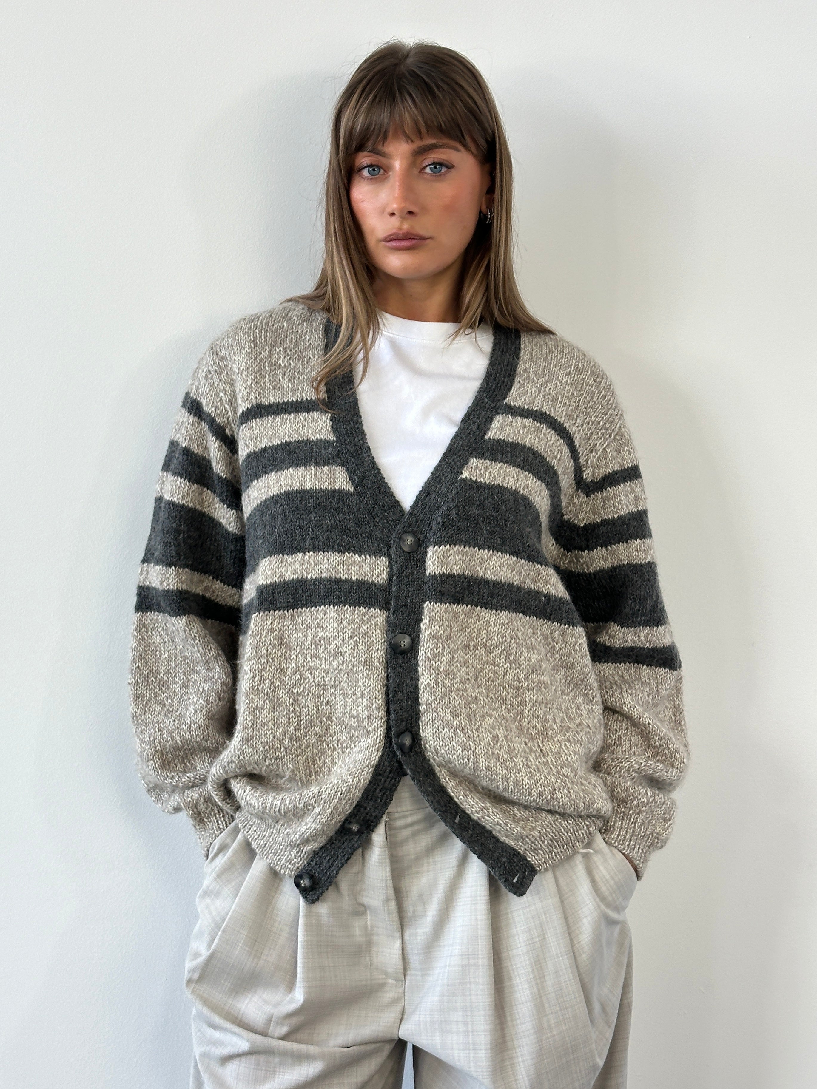 Vintage 1990s pure wool knitted stripe cardigan in size large/extra large, featuring colorful horizontal stripes and a classic fit.