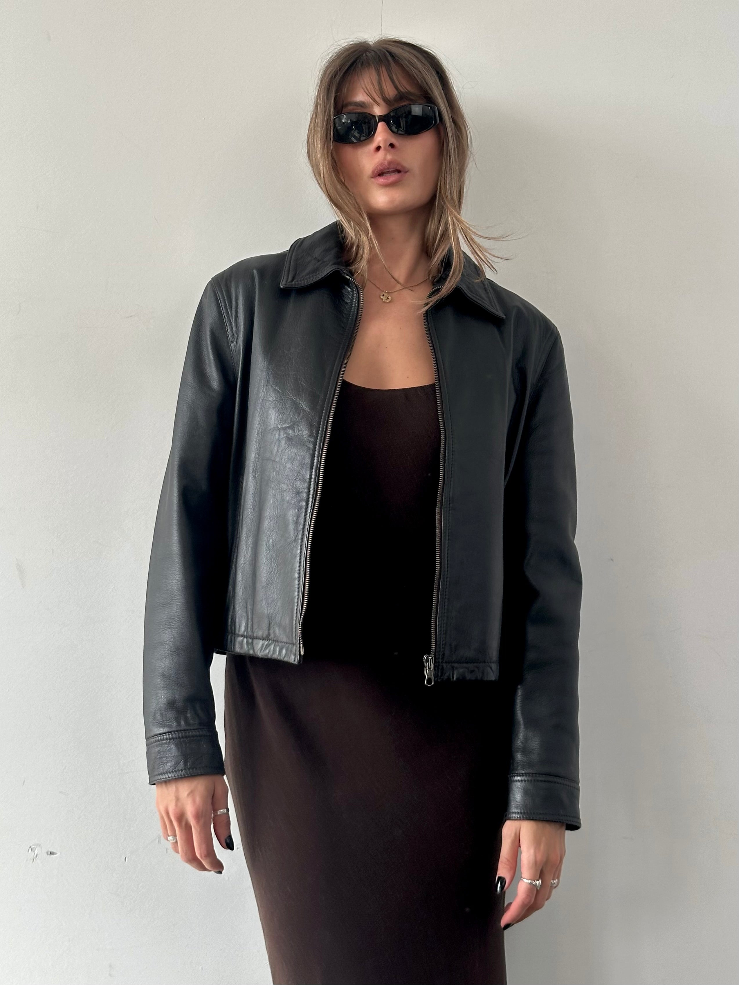 Armani Jeans leather jacket in size S/M, stylish black leather with classic design, displayed on a hanger.