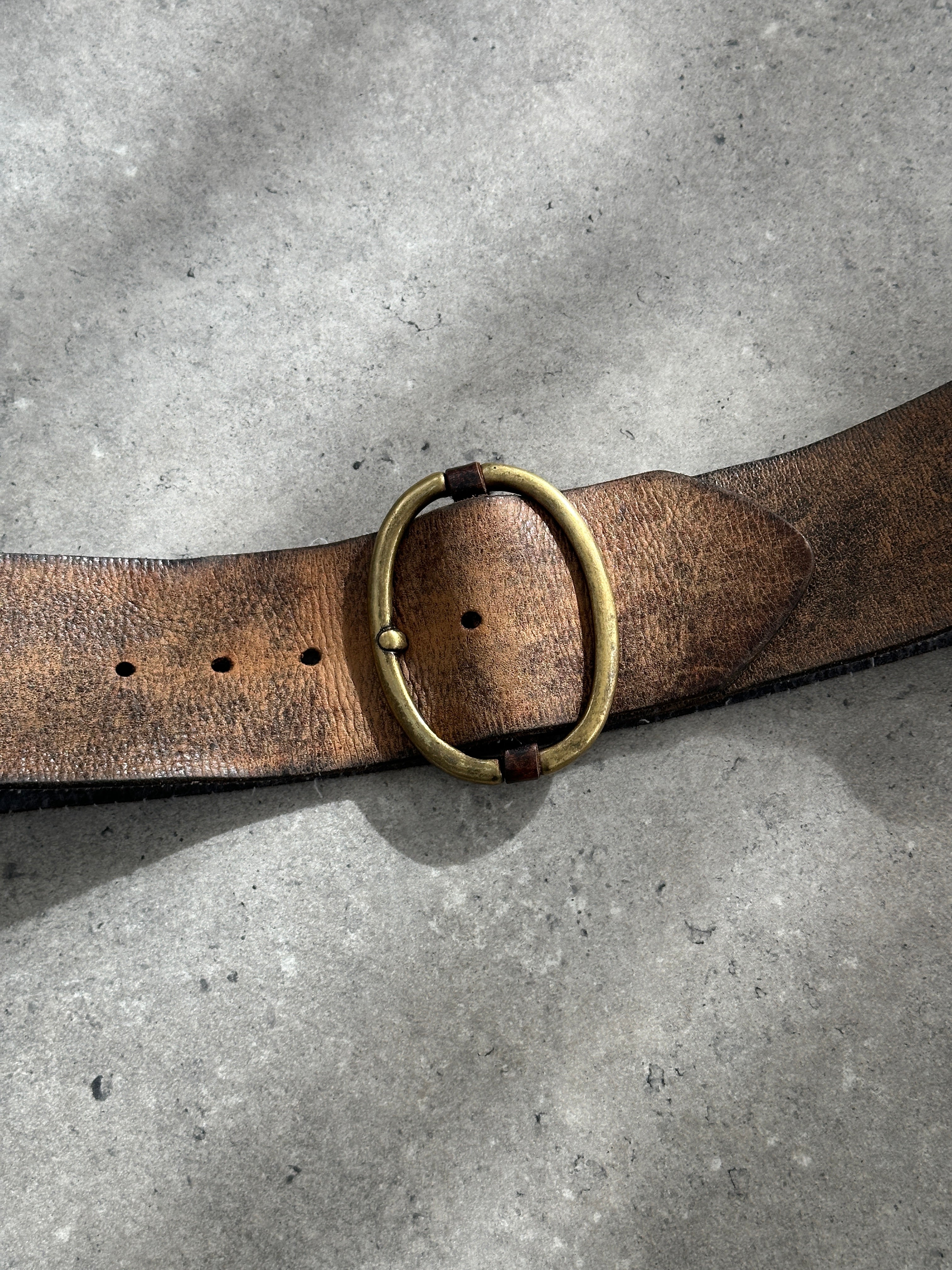 Vintage 1980s chunky leather belt with brass buckle, in worn brown leather, vintage style for retro fashion accessories.