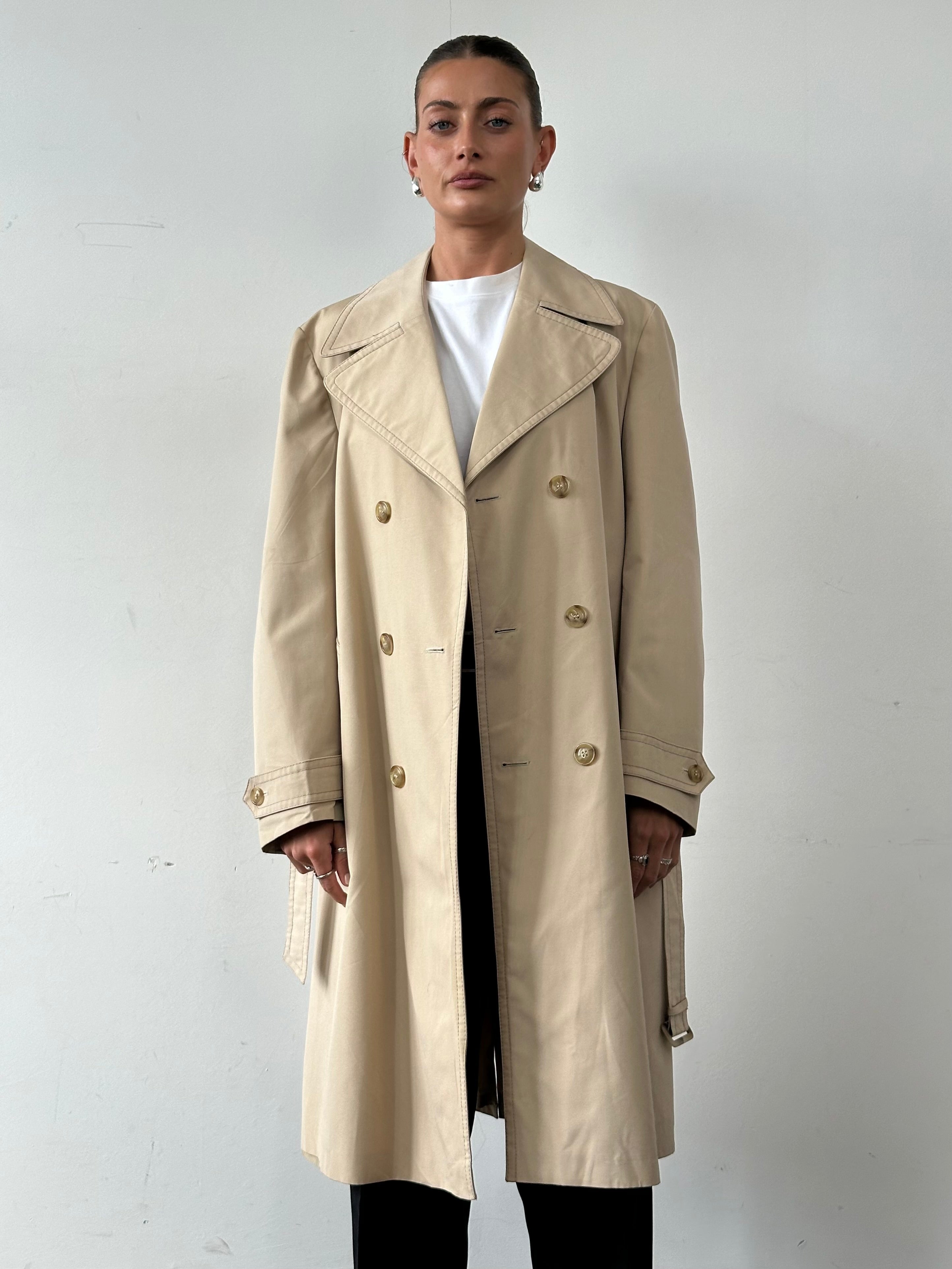 Vintage double-breasted belted trench coat in classic style, shown in a front view with lapels and button details.