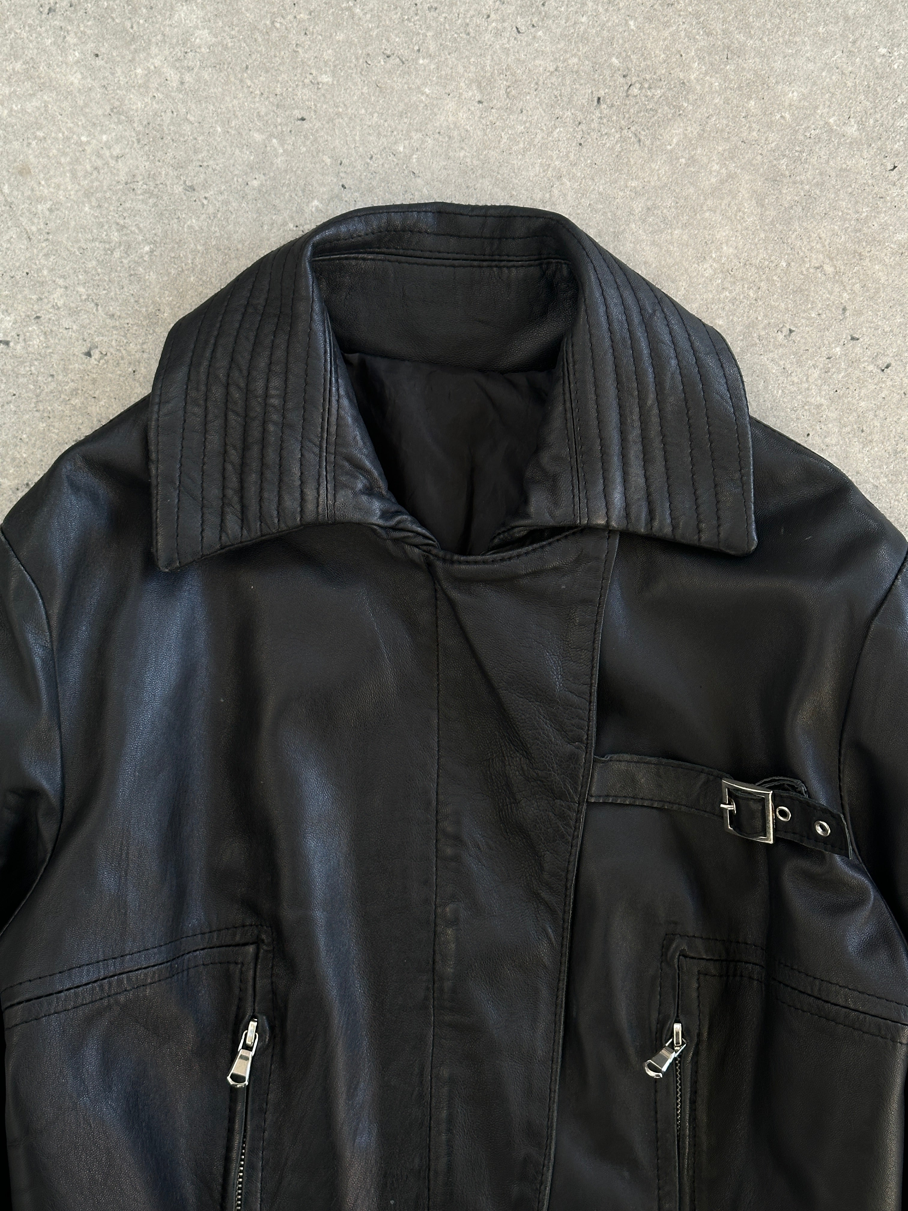Vintage Italian 1990s fitted leather jacket with buckle details, showcasing classic craftsmanship and a sleek silhouette in black leather.