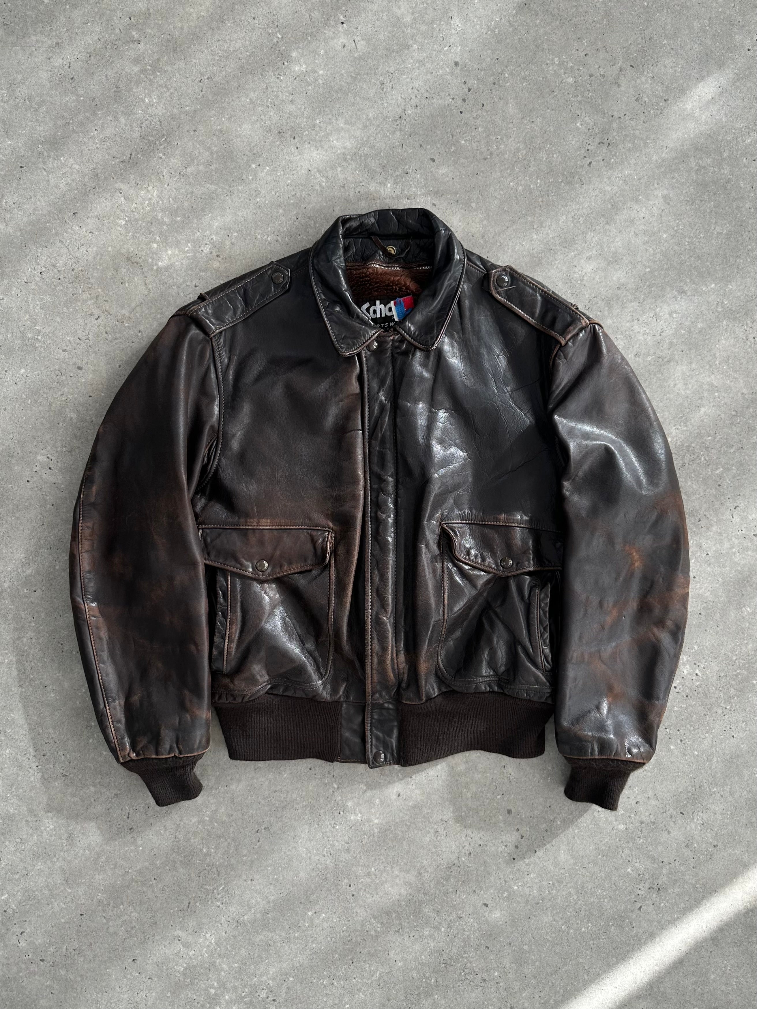 Schott NYC distressed leather bomber jacket in size L/XL with a rugged, worn-in look, featuring classic ribbed cuffs and collar.