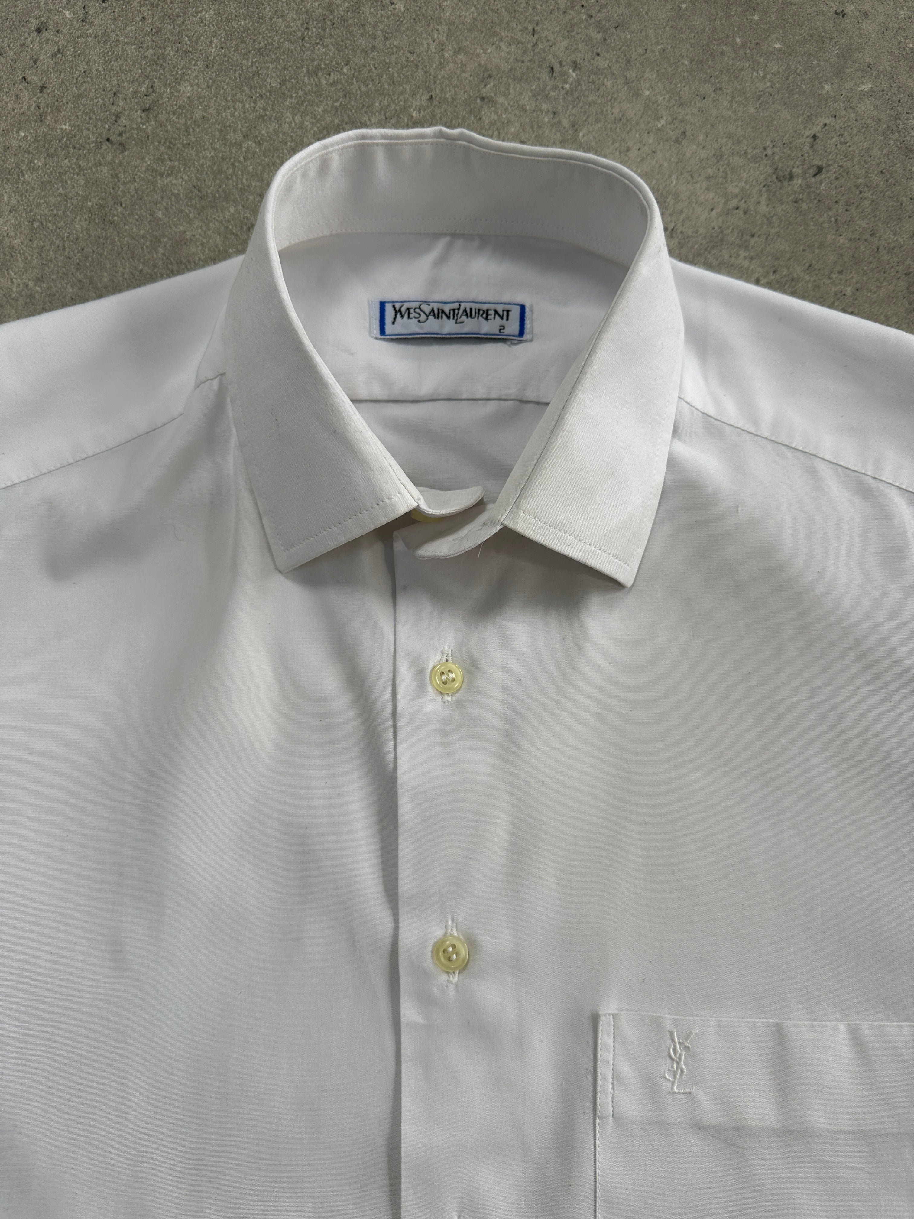 Yves Saint Laurent 1980s logo cotton short sleeve shirt in black with bold YSL branding, displayed on a hanger.