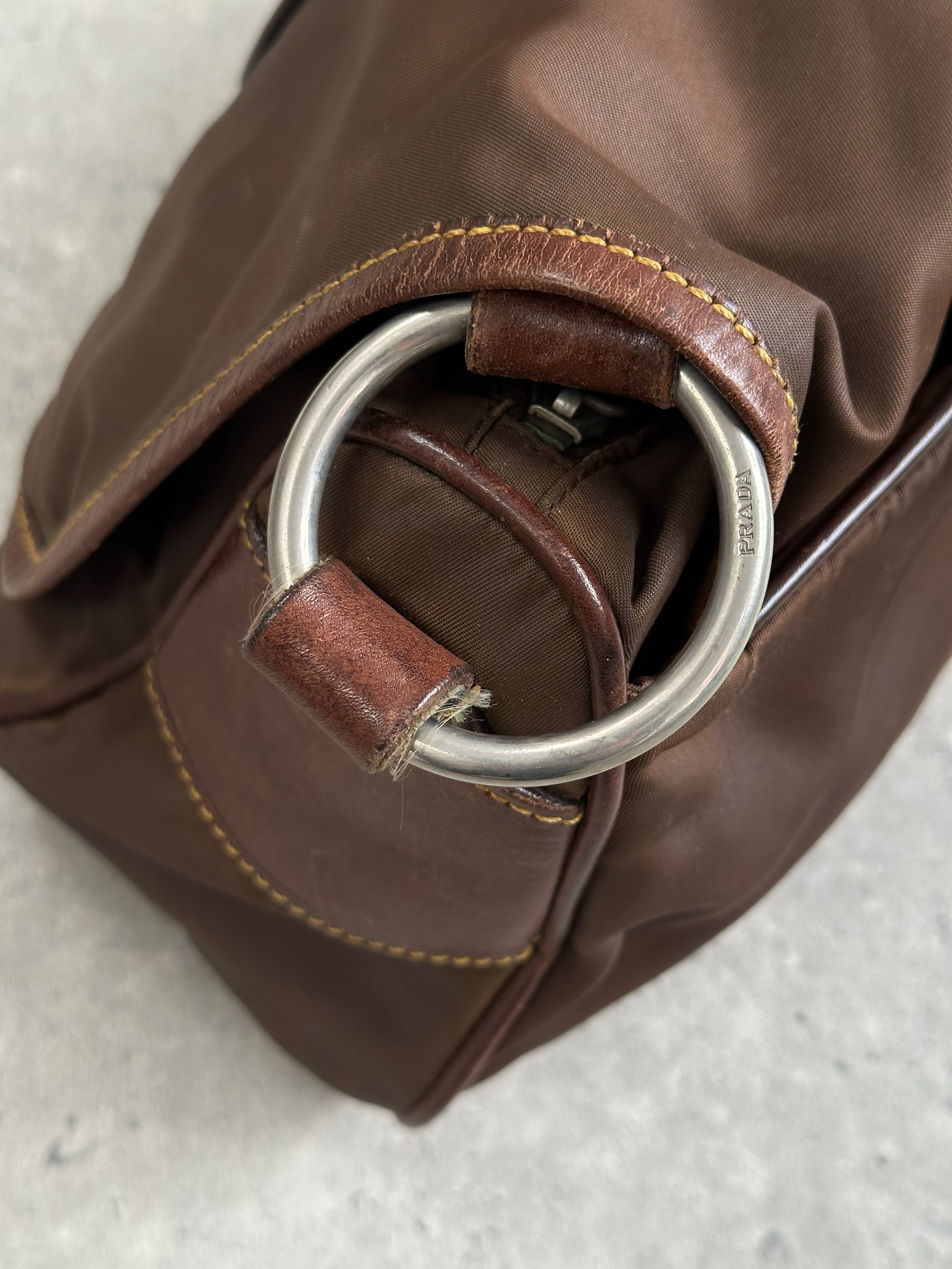 Prada 1990s nylon crossbody bag with adjustable strap and sleek design, shown in black with subtle branding details.