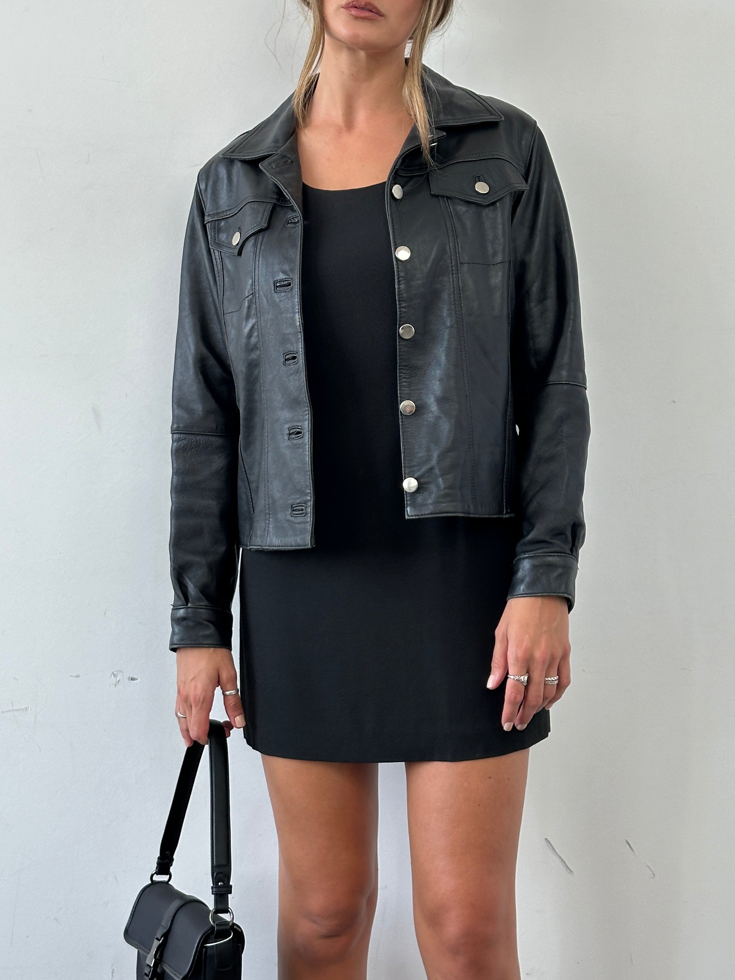 Vintage Italian leather button-up jacket in S/M size, featuring classic vintage style with detailed stitching and a sleek collar.
