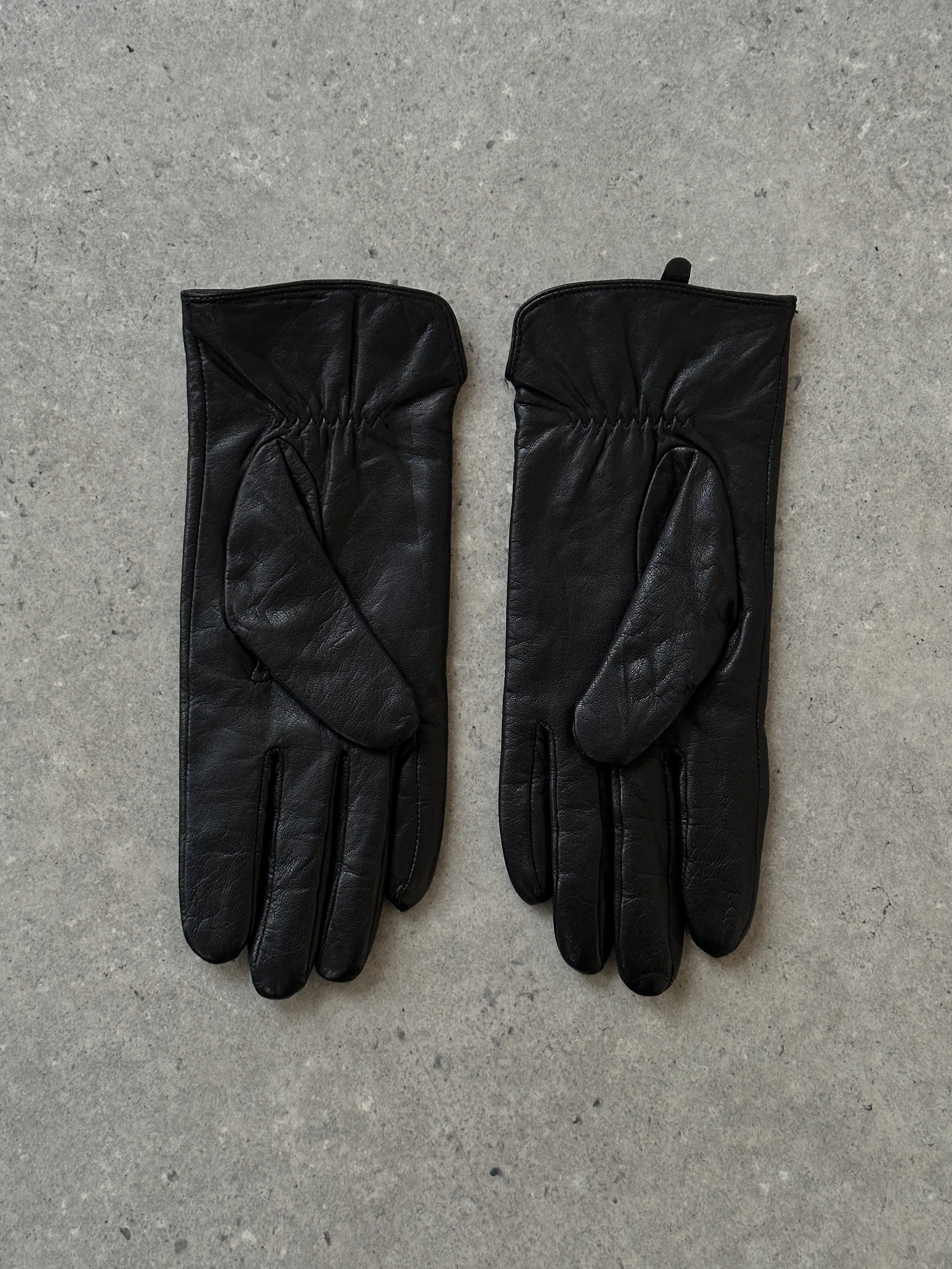 Vintage Leather Gloves, close-up of classic brown leather gloves with detailed stitching and vintage style.