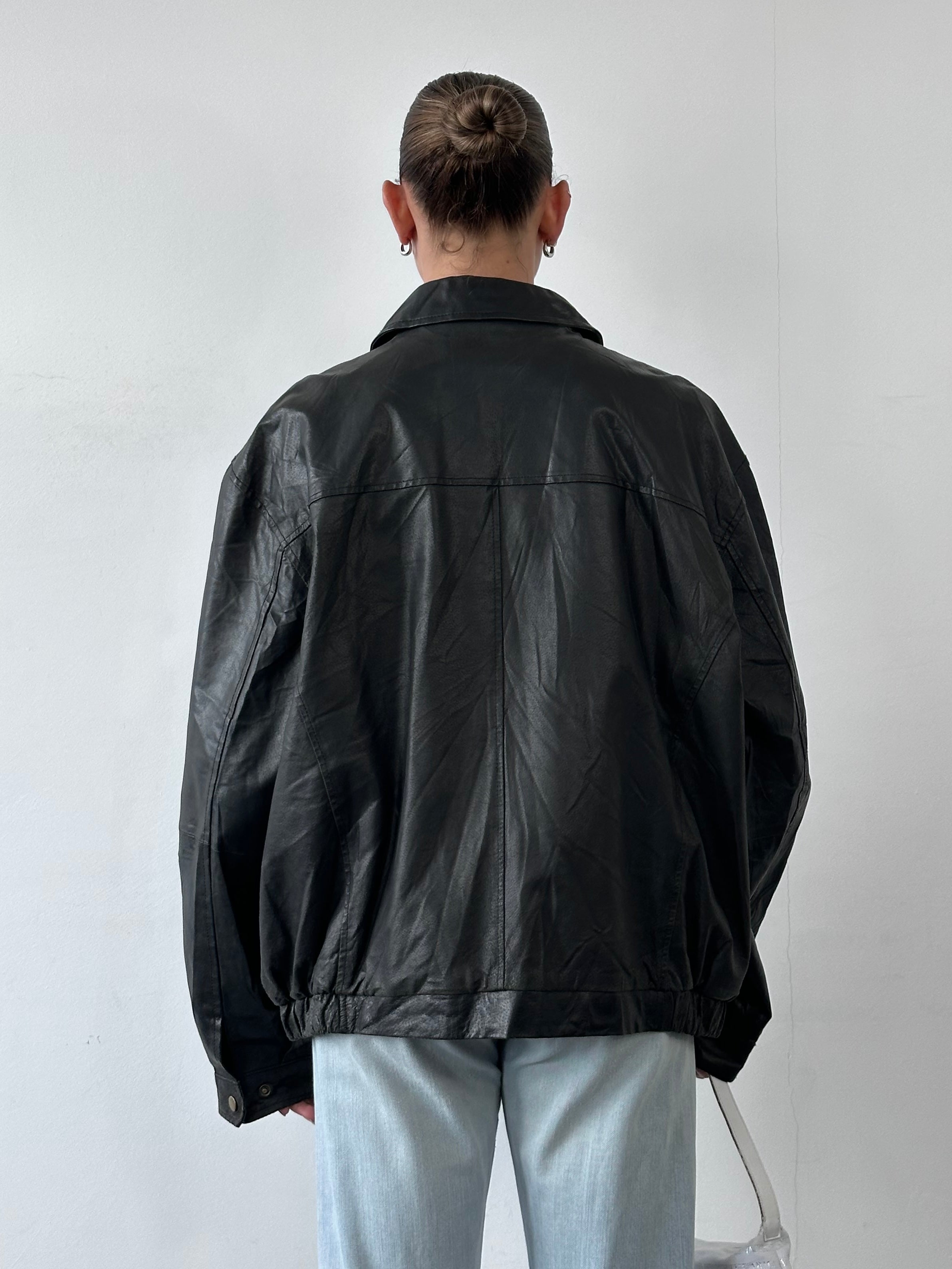 Vintage leather bomber jacket in XL, featuring a minimal design and classic style, with visible leather texture and fitted collar.
