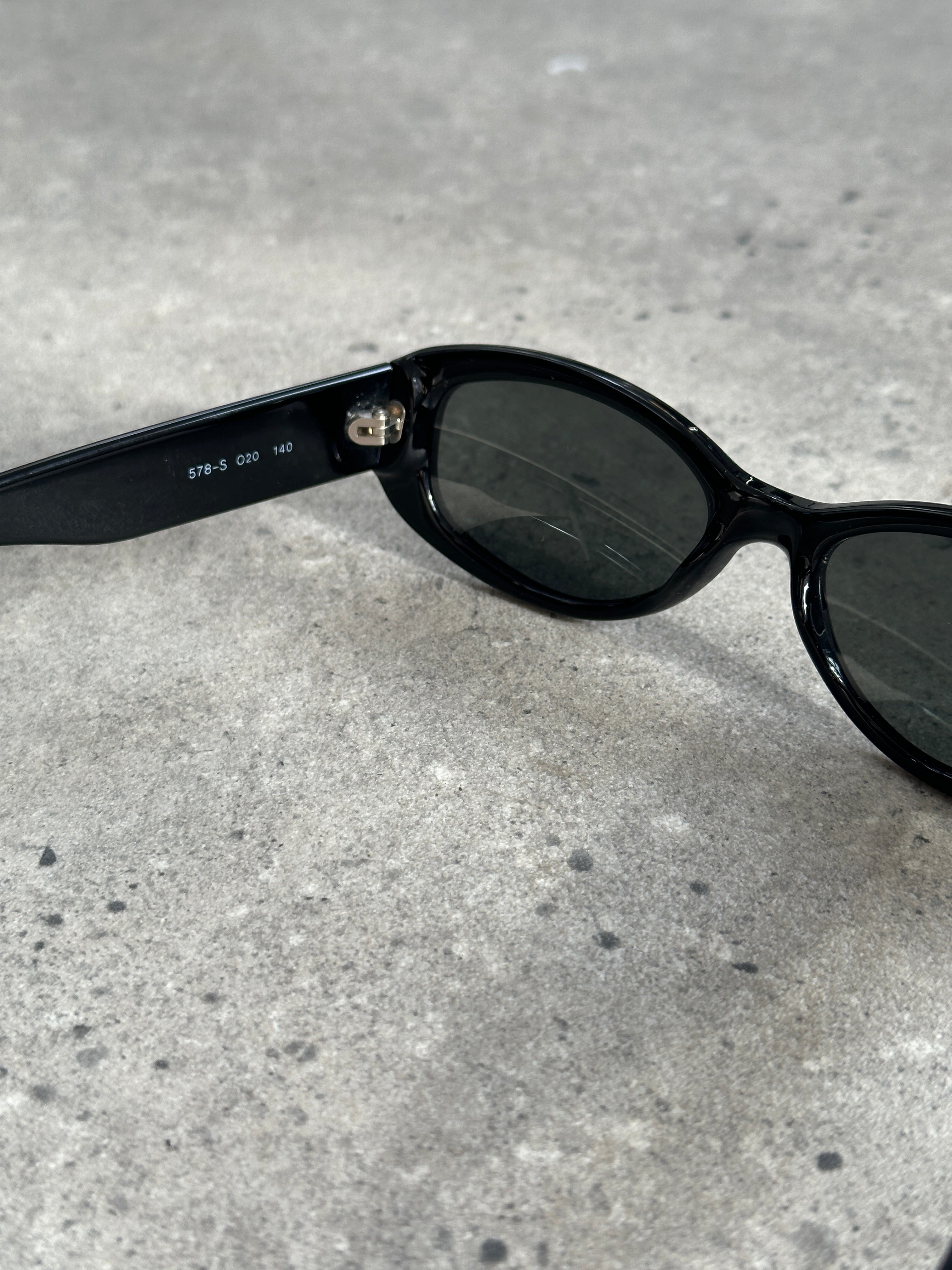 Emporio Armani oval sunglasses with dark tinted lenses and sleek black frames, stylish and fashionable eyewear.