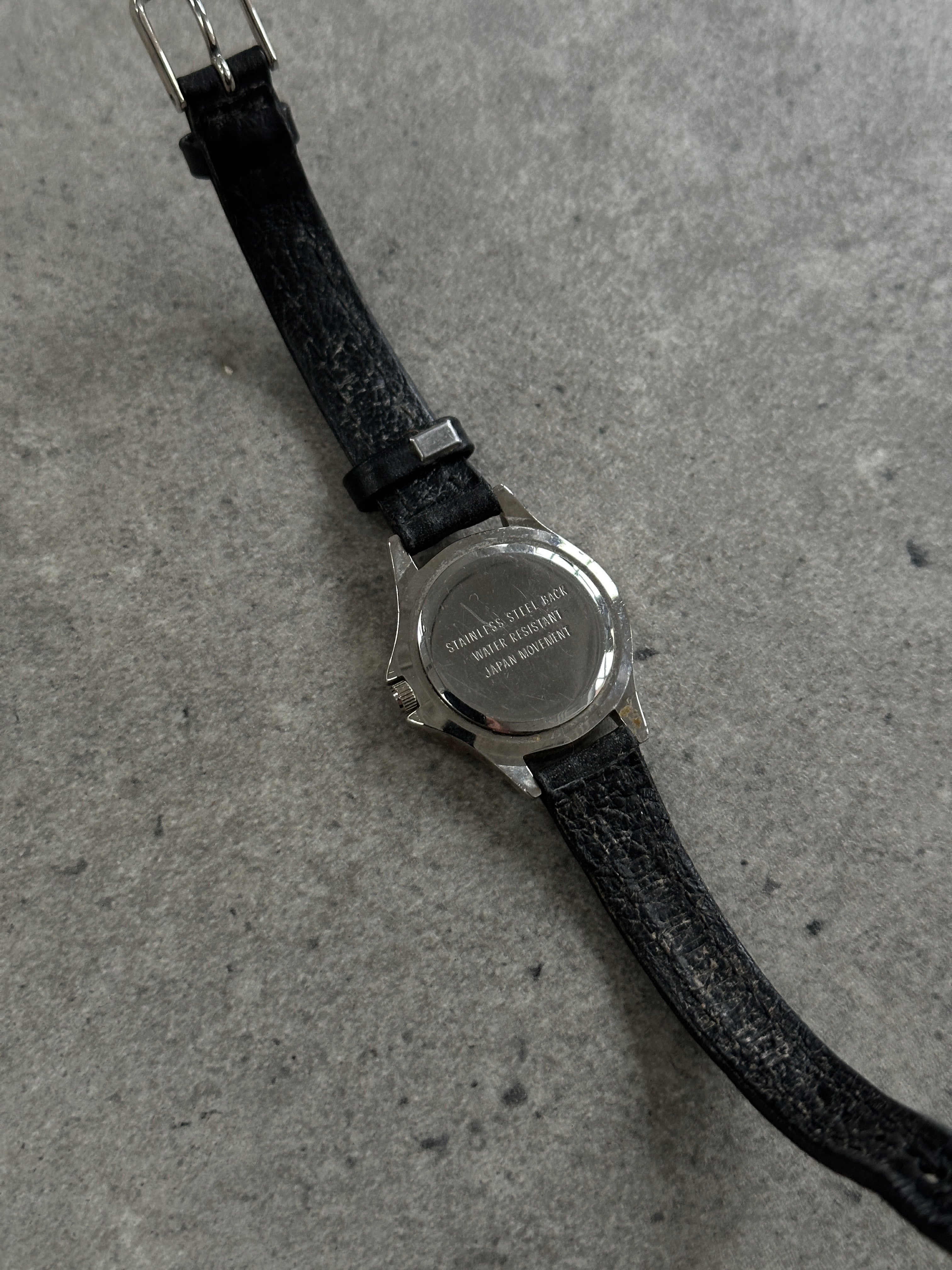 Vintage 1990s silver tone round quartz watch with Japan movement, classic vintage style and analog display.