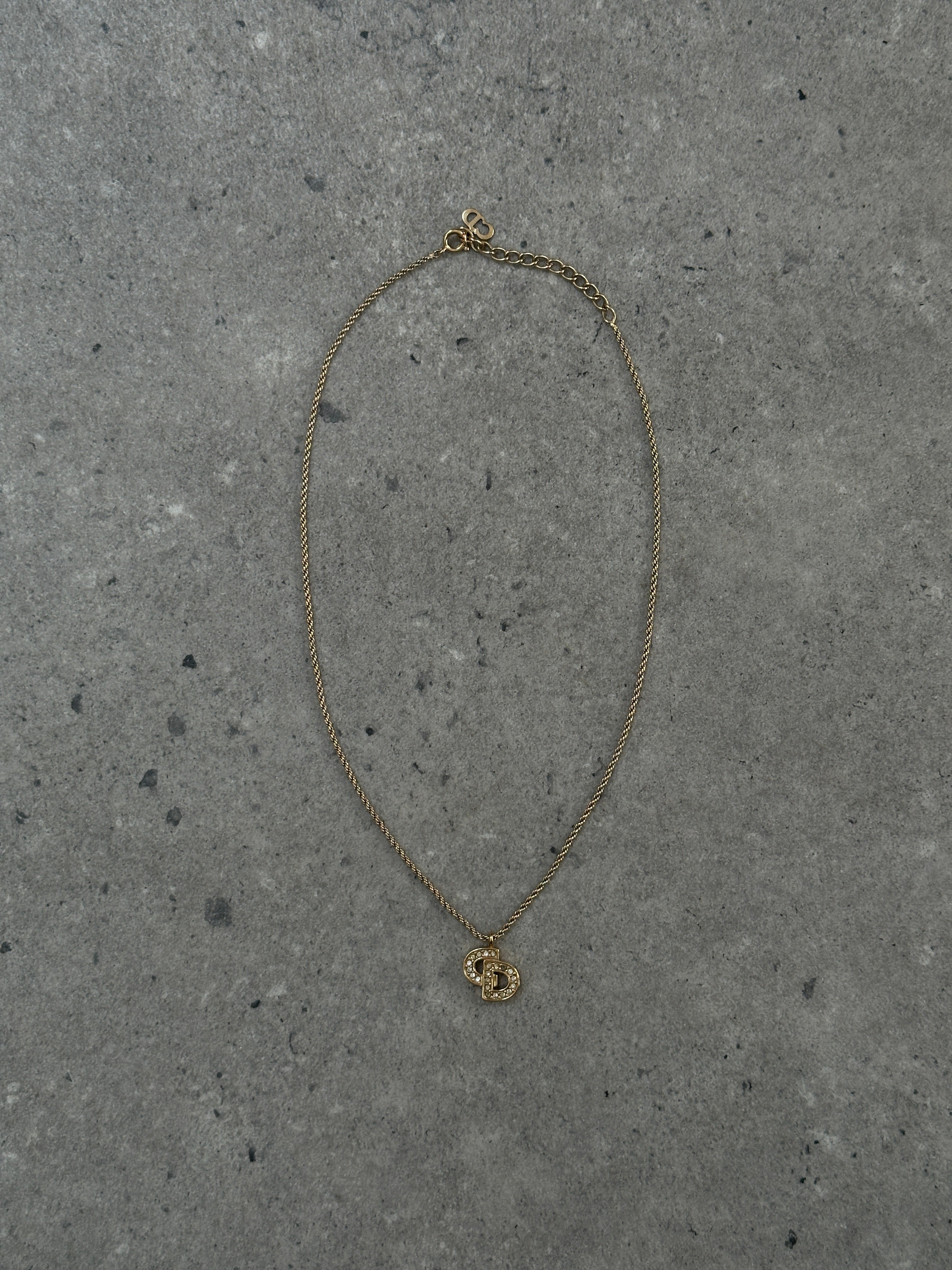 Christian Dior gold plated rhinestone logo pendant necklace, 16-inch chain with sparkling embellishments and iconic brand design.