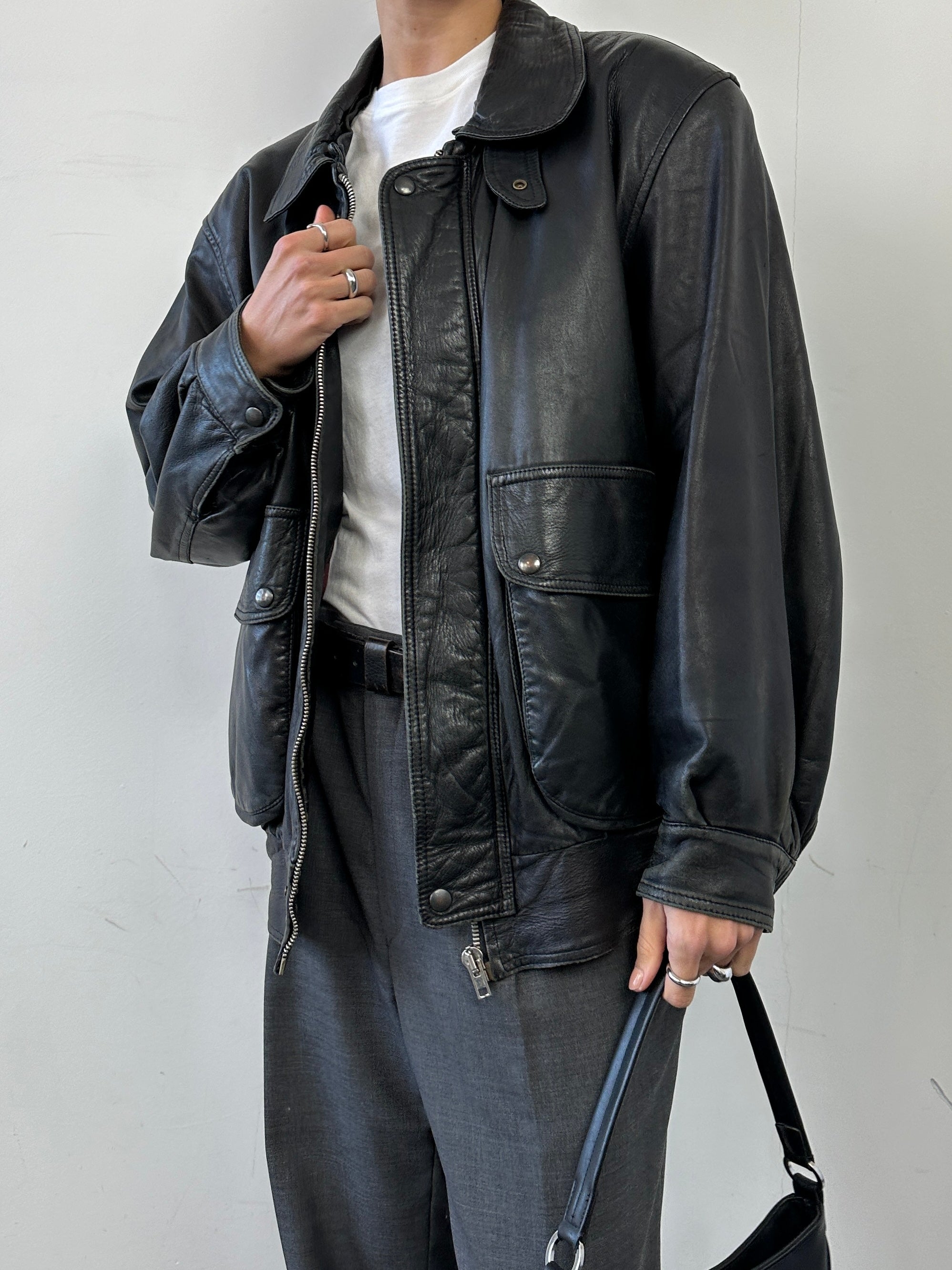 Vintage leather bomber jacket in size M/L, featuring classic design and durable material, shown on a hanger.