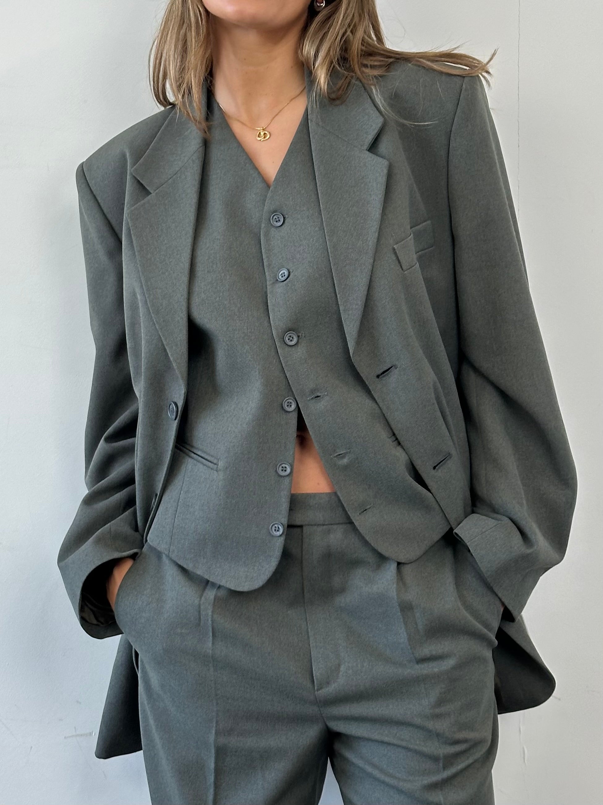 Vintage three-piece suit in size 44R, featuring a classic tailored design with jacket, vest, and trousers.