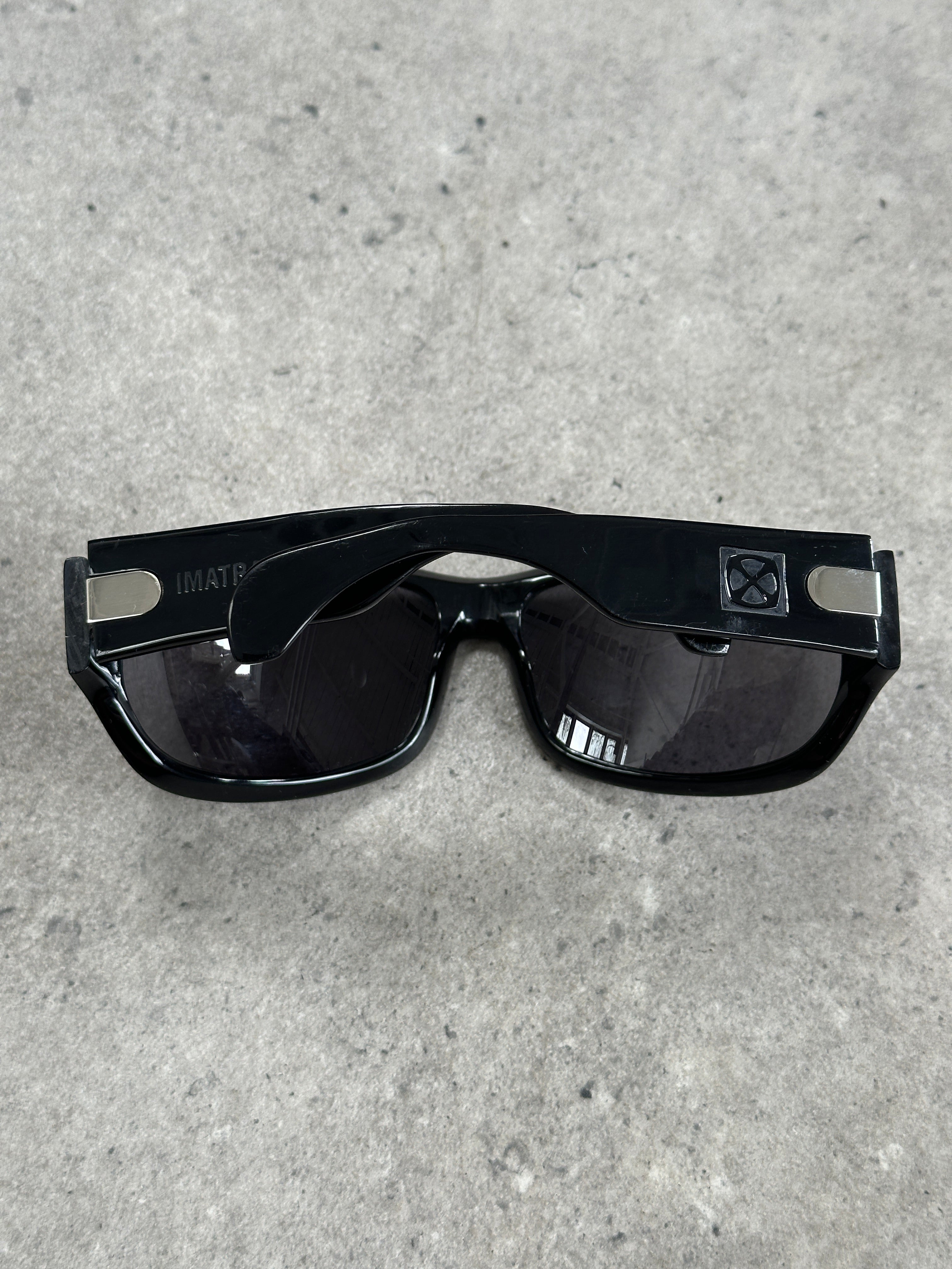 Vintage 2000s oversized shield sunglasses with bold design and dark tinted lenses, showcasing a retro fashion style.