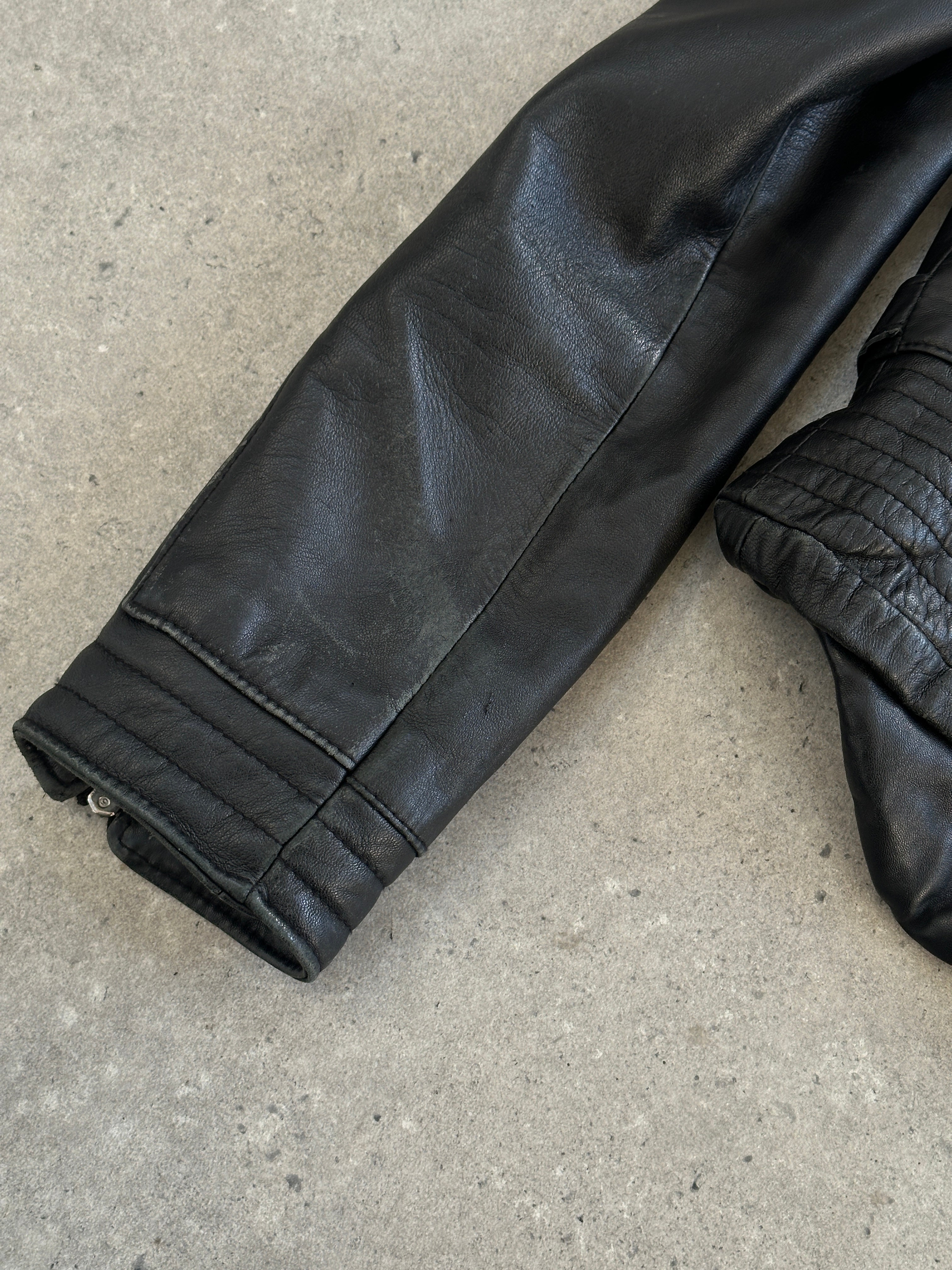 Vintage Italian 1990s fitted leather jacket with buckled details, size small, classic vintage leather fashion piece.