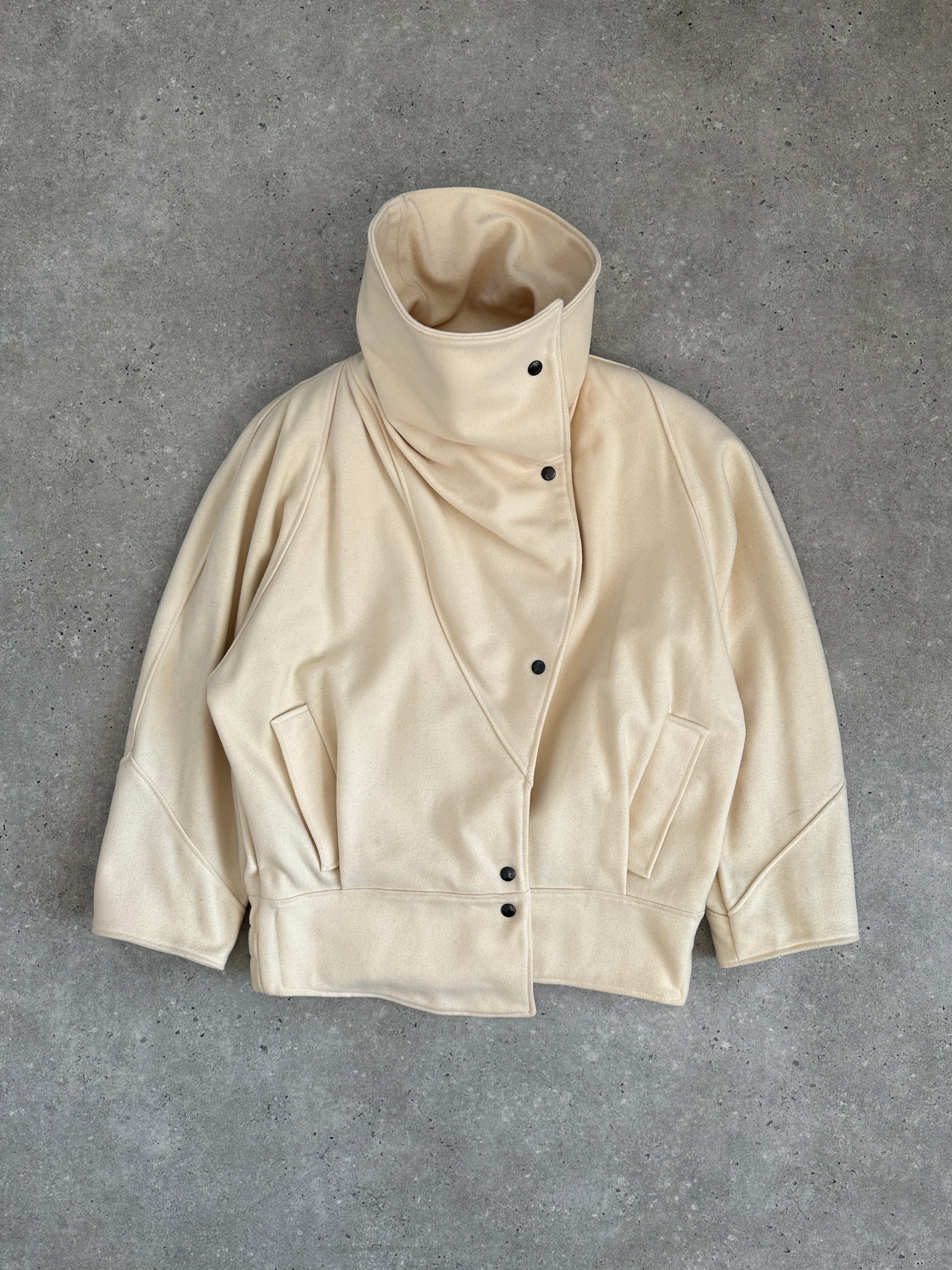 Vintage asymmetric wool bomber jacket with funnel neck, in classic design, shown on a hanger.