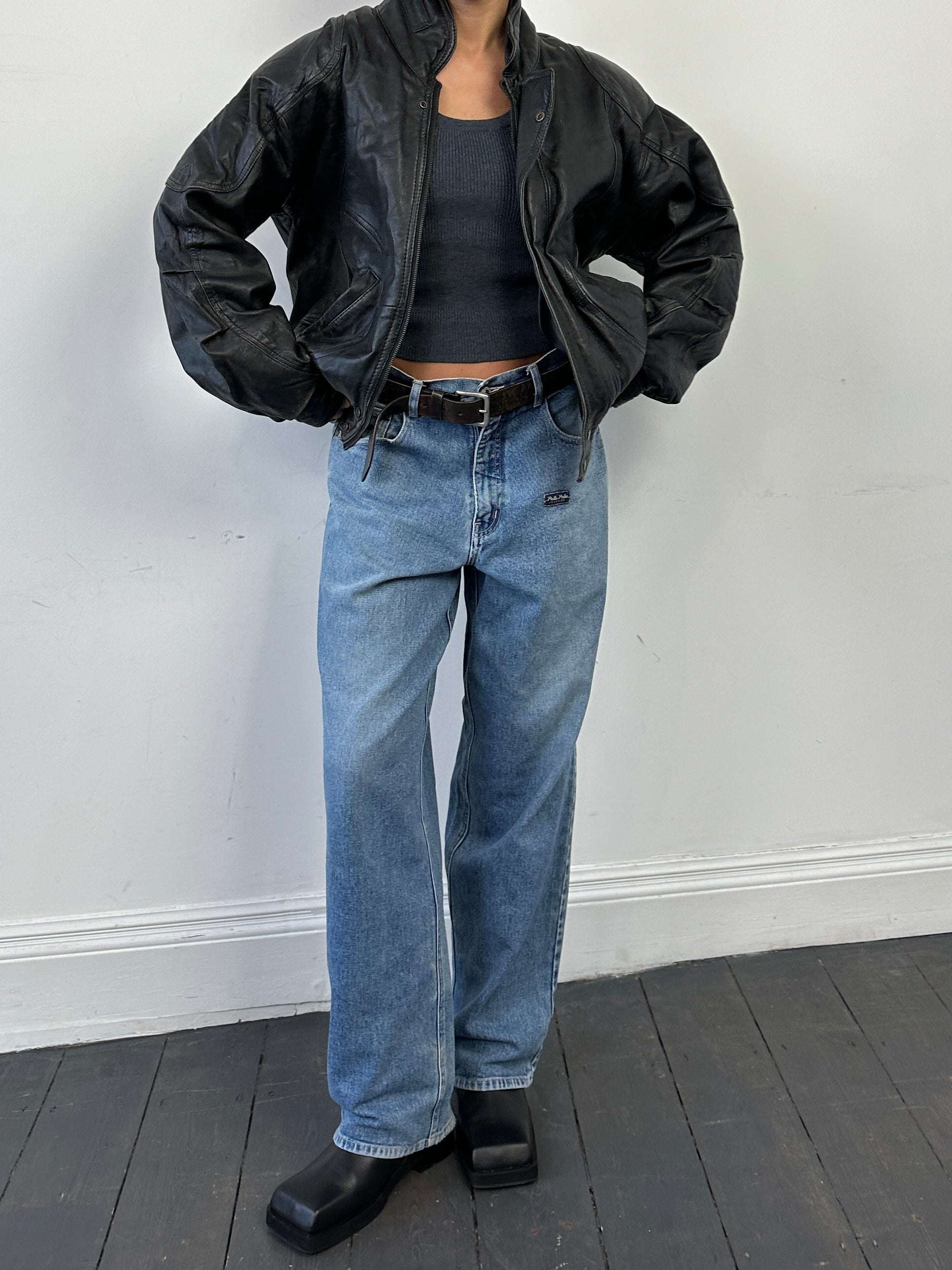 Vintage leather bomber jacket in size M, featuring classic design and durable leather material, displayed on a hanger.