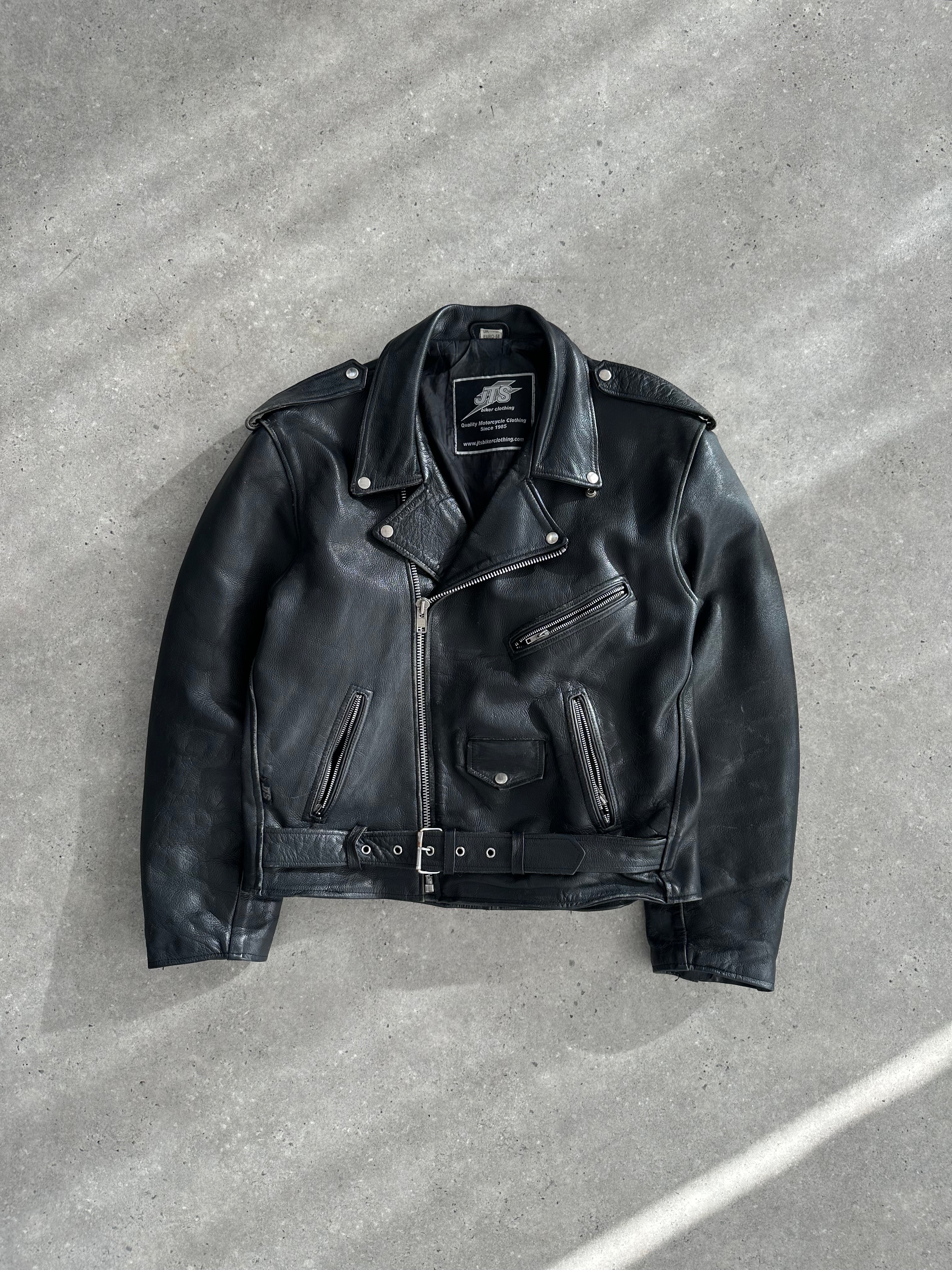 Vintage leather biker jacket in size XL, featuring classic design, rugged texture, and detailed stitching on a hanger.