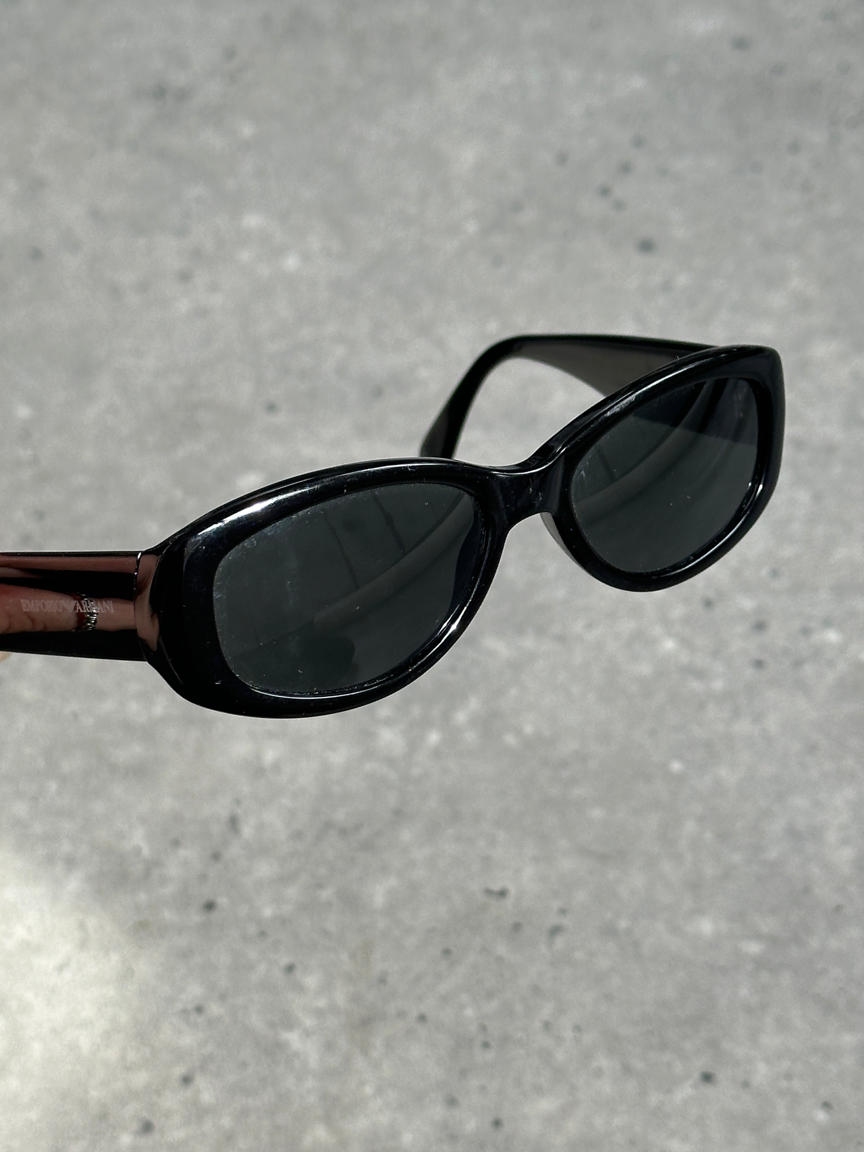 Emporio Armani oval sunglasses with dark tinted lenses and sleek black frames, stylish and modern eyewear.