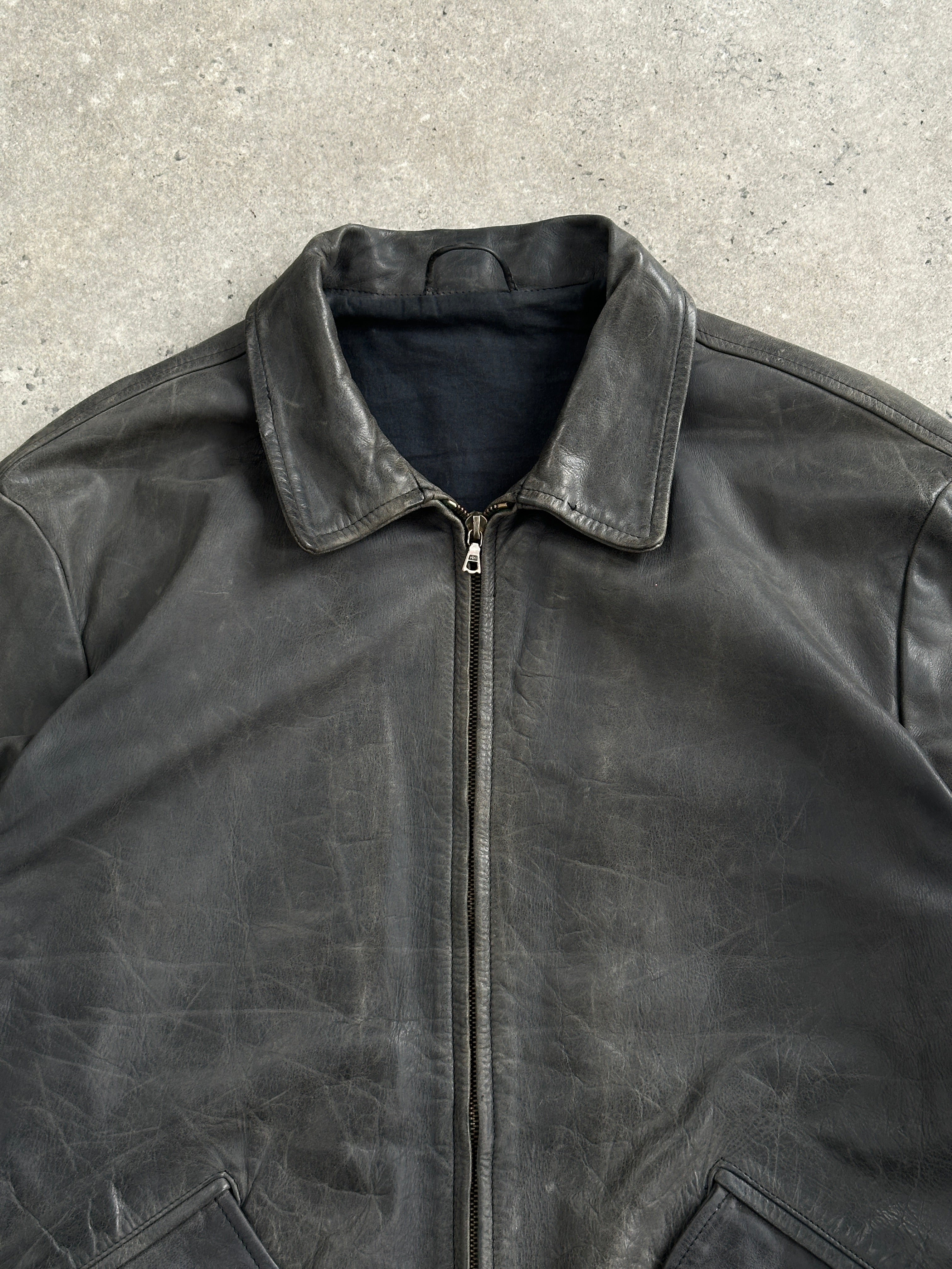 Vintage 1990s aged boxy leather jacket in size L/XL, featuring distressed brown leather and classic design.