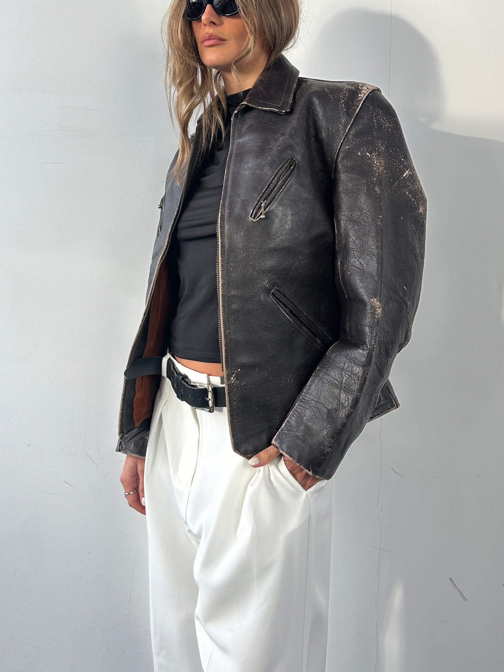 Vintage distressed leather jacket in size S/M, structured design with a rugged, vintage look and classic leather texture.